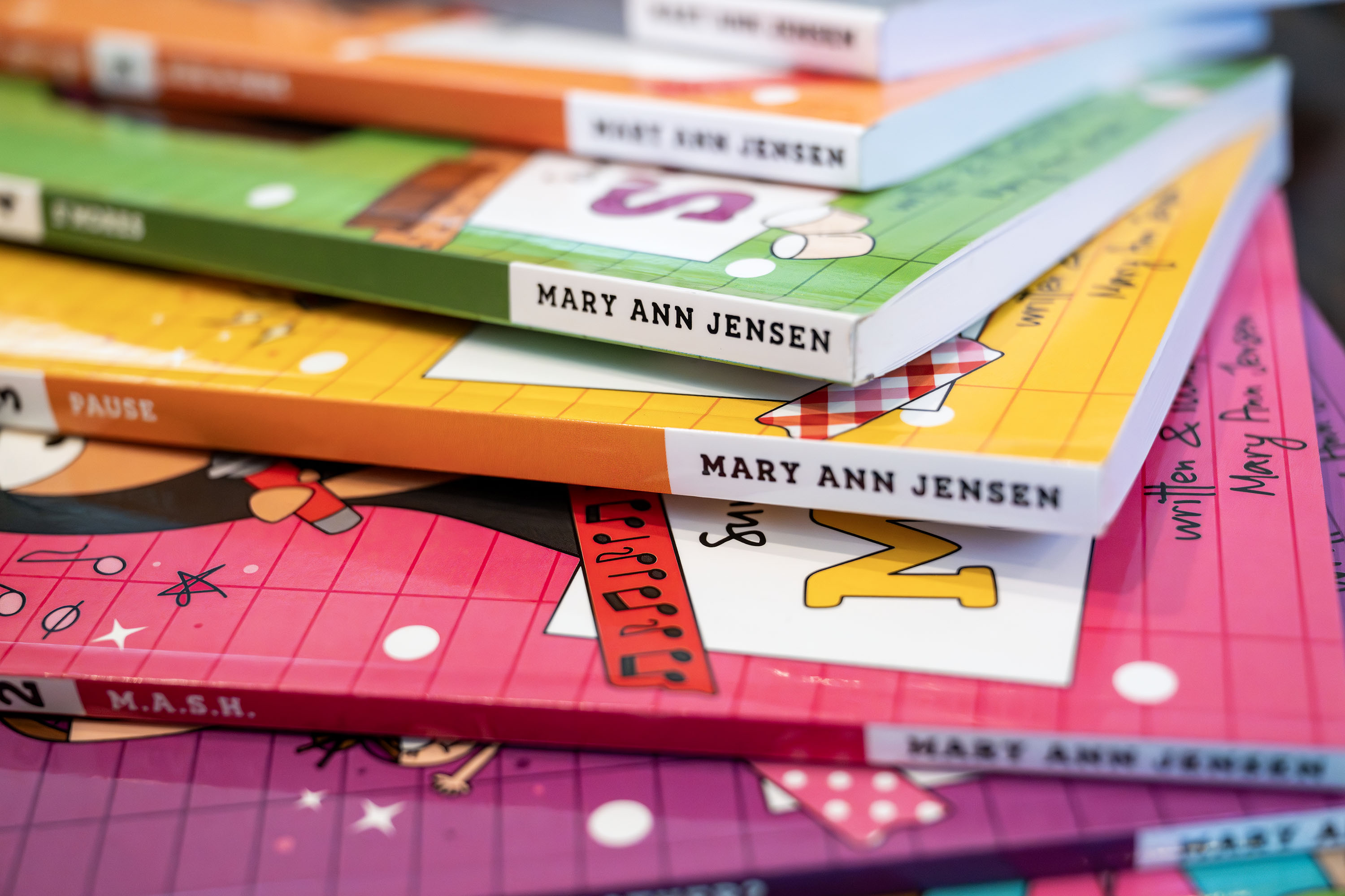 Self-published books by teen author Mary Ann Jensen sit on a table as Jensen poses for photos at her home in Cottonwood Heights on Monday. Jensen has just completed her seventh self-published book.