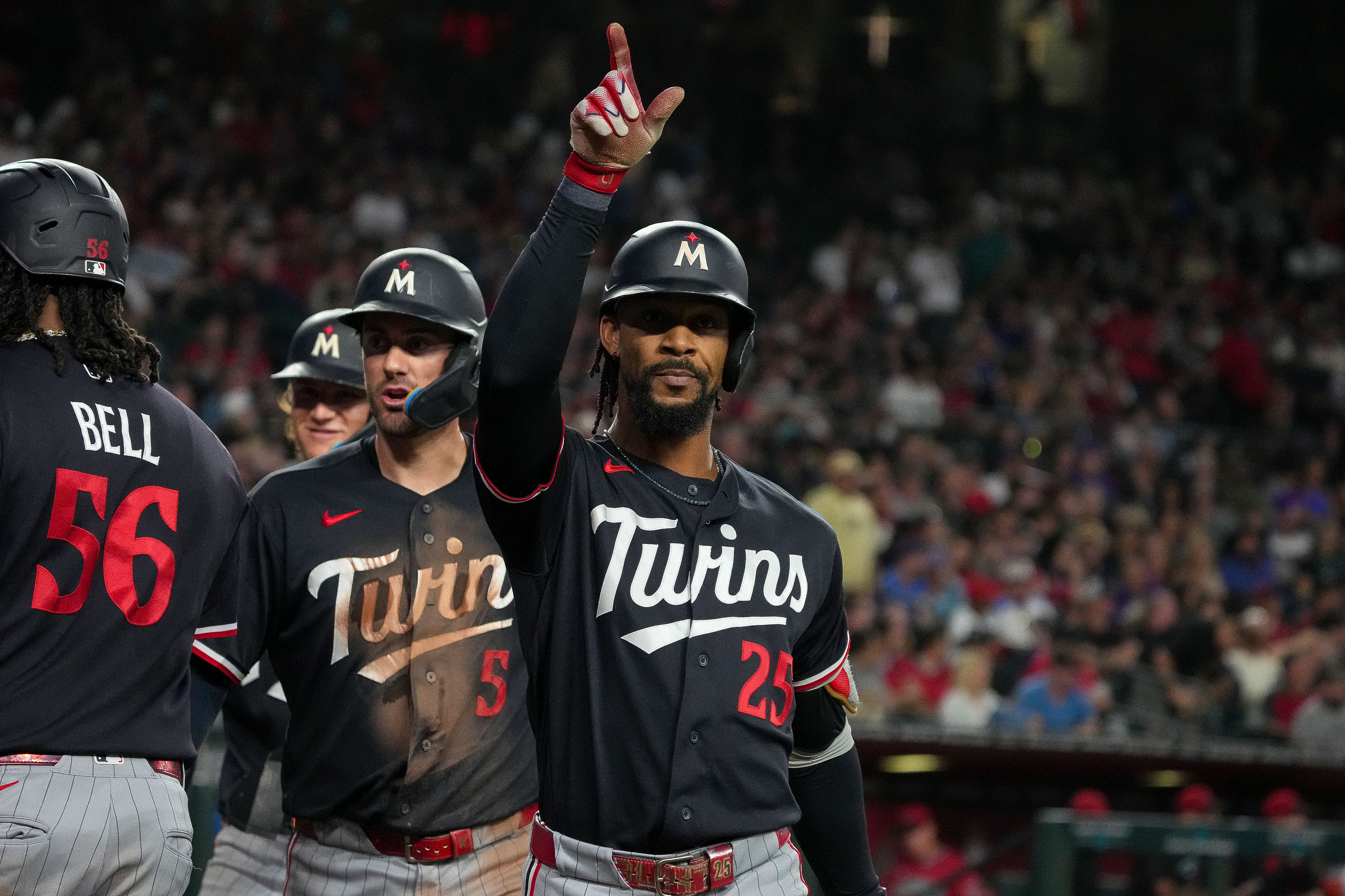 Minnesota Twins' Byron Buxton (25) celebrates after hitting a grand slam with teammates Josh Bell (56) and Ryan Kreidler (5) in the fifth inning of a baseball game against Arizona Diamondbacks Saturday, June 20, 2026, in Phoenix.