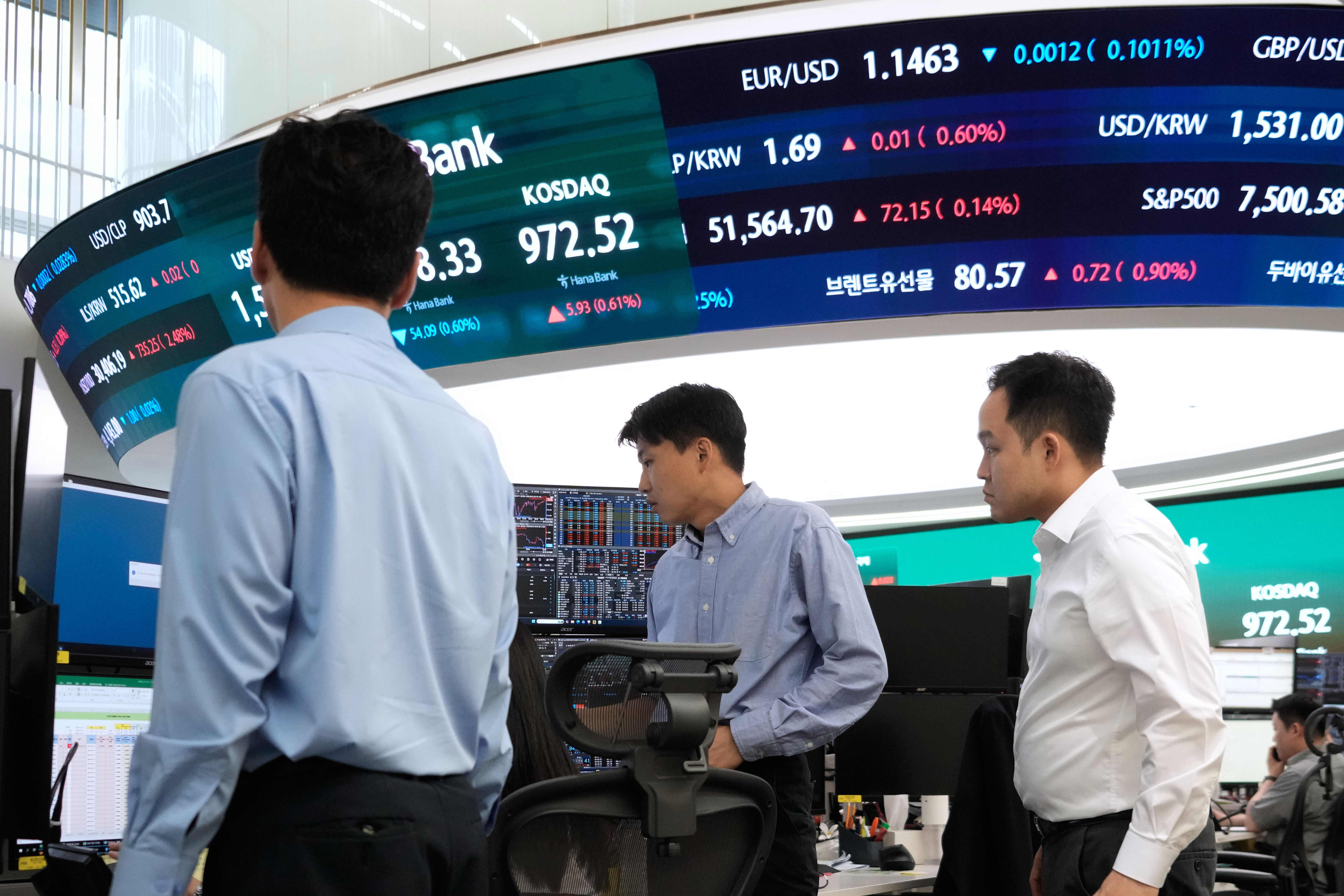 Currency traders work at the foreign exchange dealing room of the Hana Bank headquarters in Seoul, South Korea, Monday, June 22, 2026.