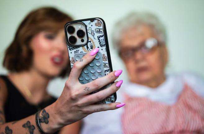 Shelby Coleman, left, and her grandmother VaLynne Thompson, right, film a TikTok at Thompson’s home in Mapleton on June 4. The pair run a TikTok account together.