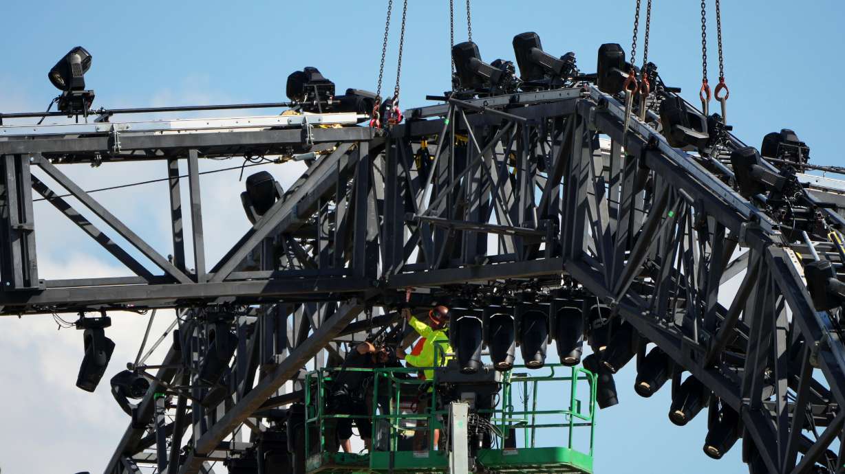 A worker on a lift uses a sledge hammer as crews work to disassemble the structure that was built for UFC Freedom 250 at the White in Washington, Sunday. Two more people have been arrested in connection with what authorities say was a planned attack targeting President Donald Trump's UFC cage-fighting show