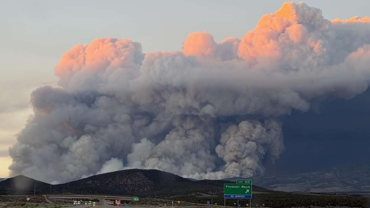 The Cottonwood Fire burns near Beaver, in central Utah, on Monday as smoke is seen from I-15.