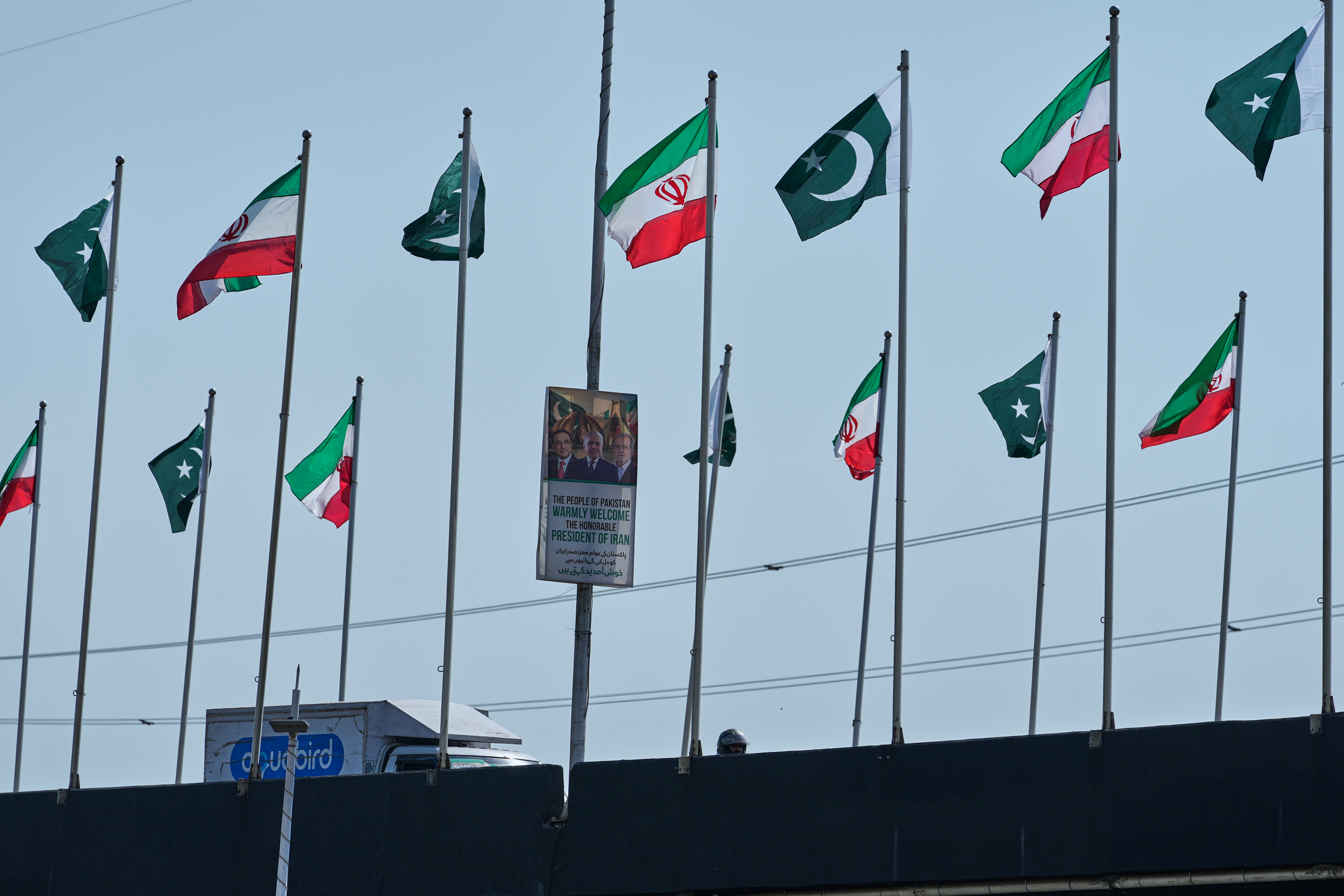 The welcoming billboard, featuring Iranian President Masoud Pezeshkian, with Pakistan President Asif Ali Zardari and Prime Minister Shehbaz Sharif, is displayed alongside of an overhead bridge, in Islamabad, Pakistan, Tuesday. Pezeshkian made his first visit since the war started.
