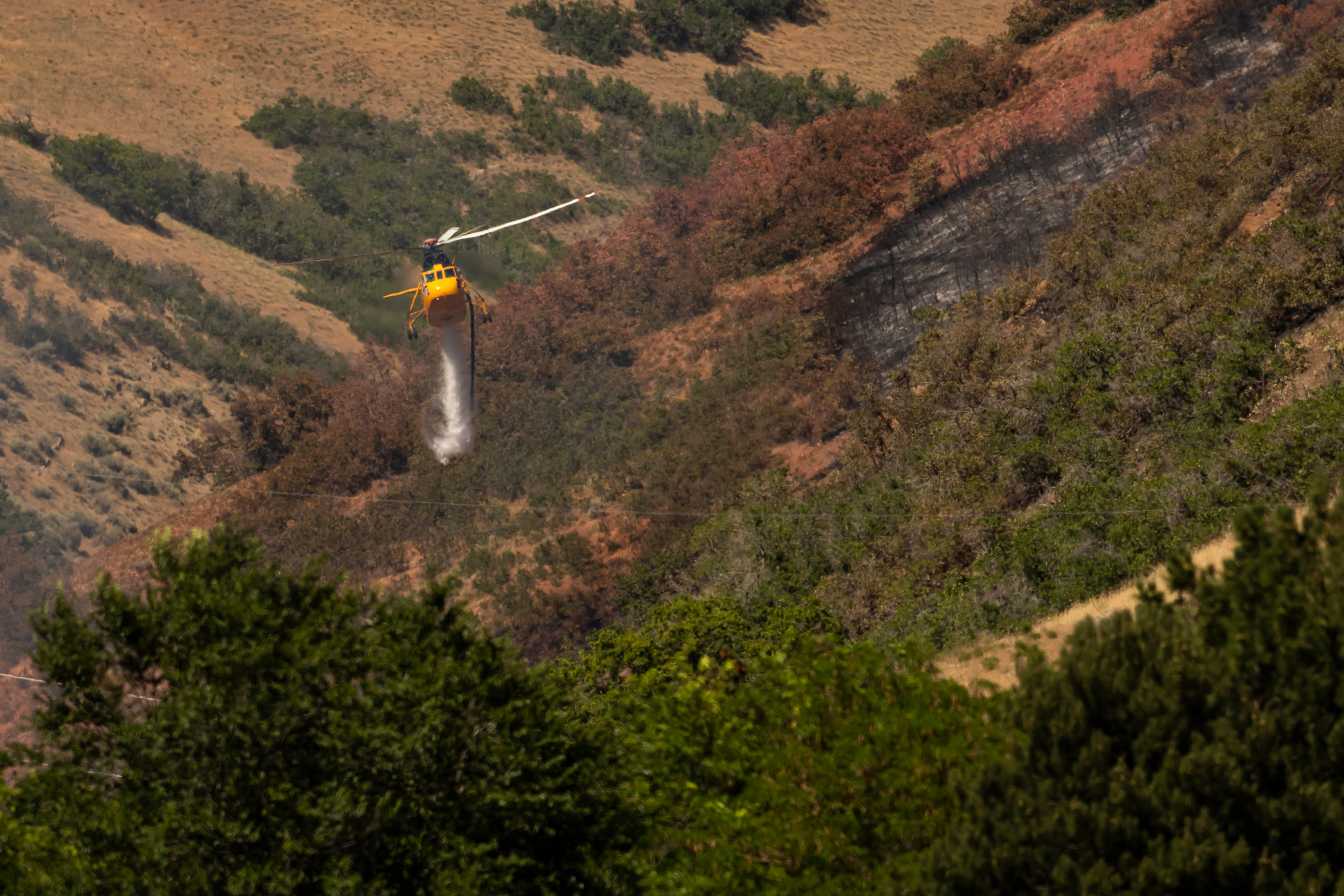 A helicopter dumps water on the Bonneville Fire above the University of Utah in Salt Lake City on Sunday. Utah is in a high-risk region for wildfires this summer due to a low snowpack and above-average temperatures.