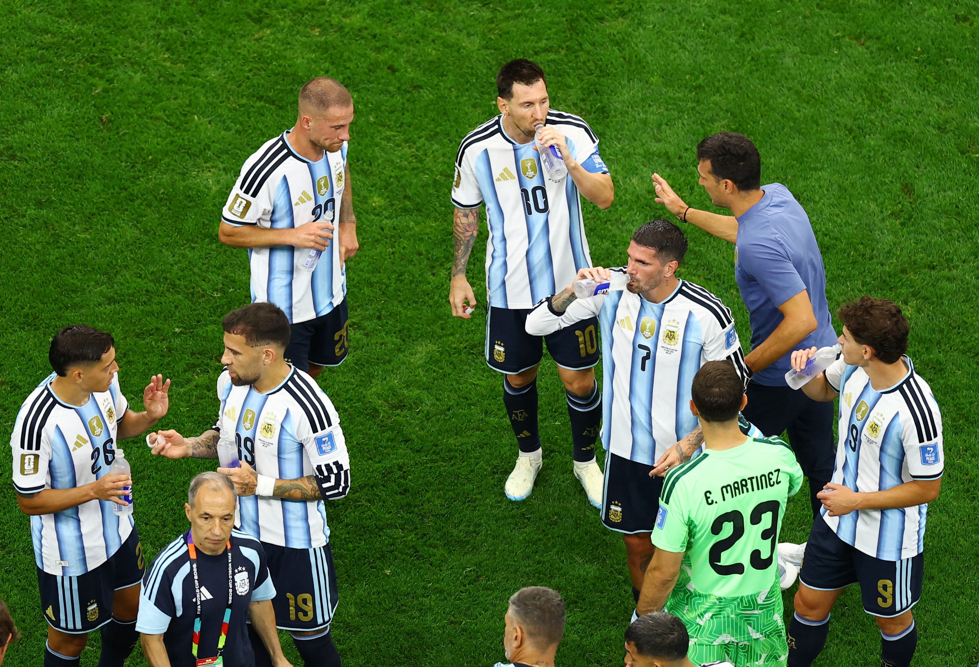 Argentina coach Lionel Scaloni talks to forward Lionel Messi and midfielder Alexis Mac Allister during a hydration break during their match against Austria on Monday. Hydration breaks have become grounds for sing-alongs at the World Cup.