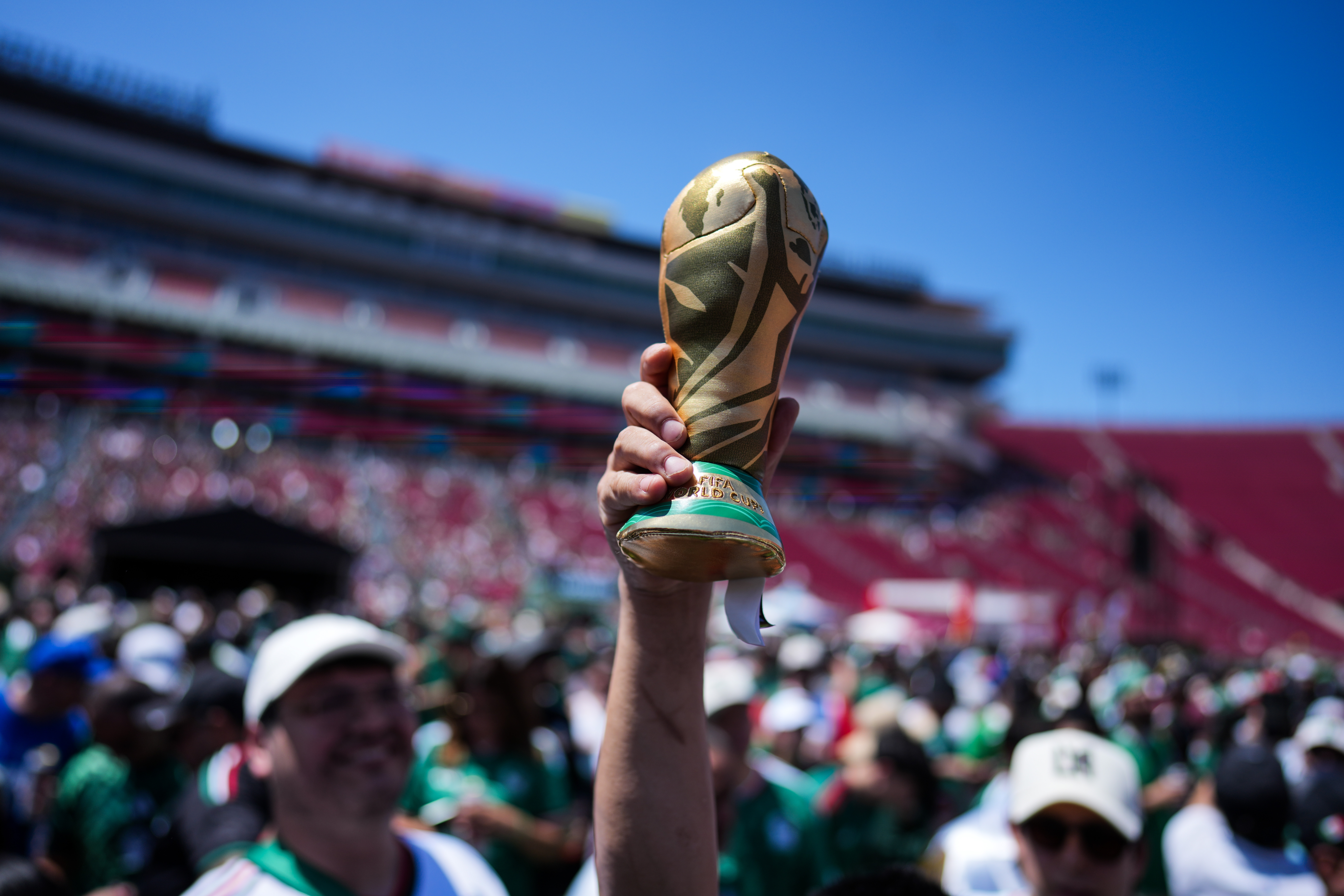 A fan holds up a replica of the World Cup trophy at a fan festival at the Los Angeles Memorial Coliseum in Los Angeles, Thursday, June 11, 2026, during a live broadcast of the World Cup soccer match between Mexico and South Africa.