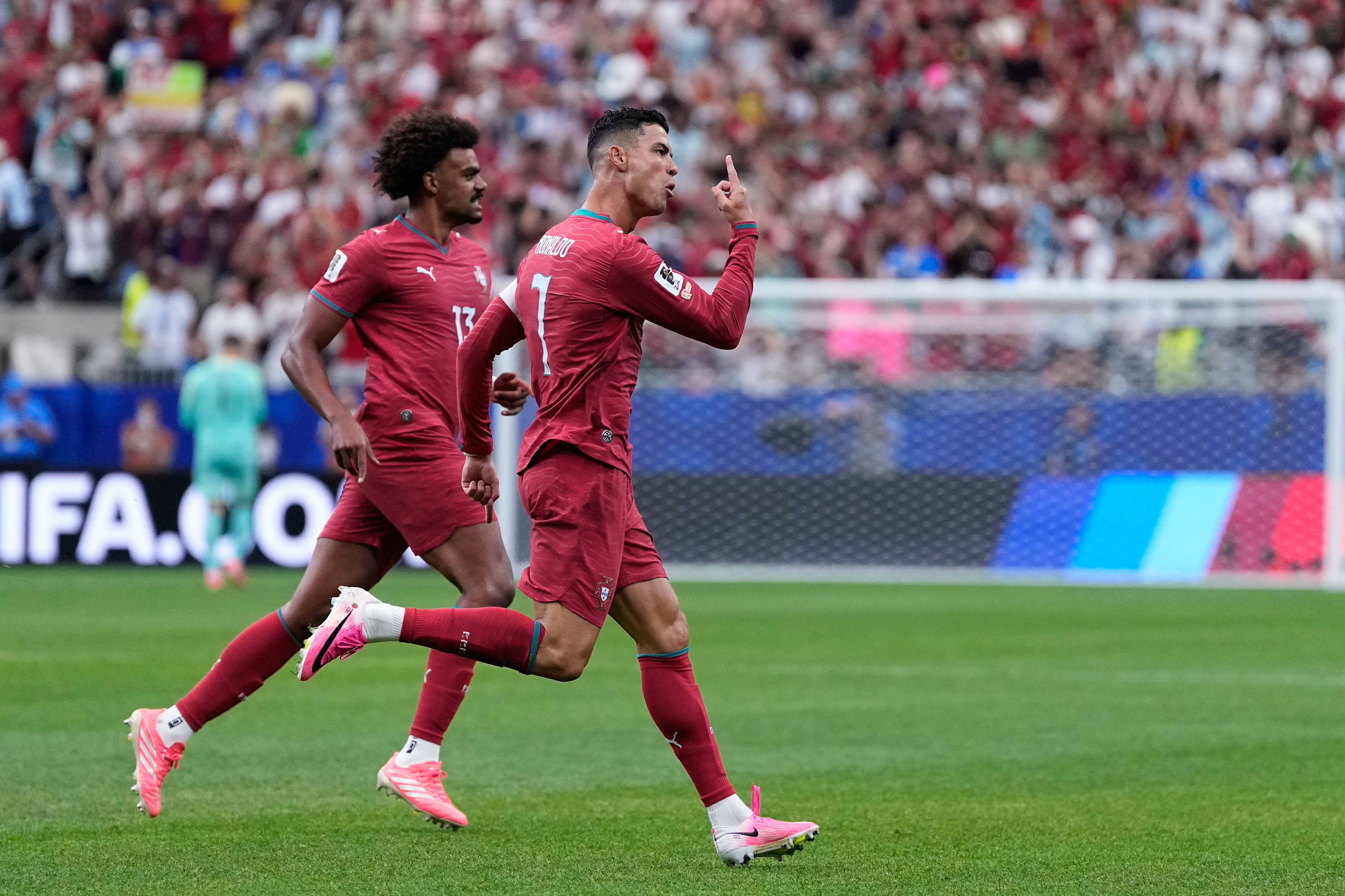 Portugal's Cristiano Ronaldo, right, celebrates after scoring the opening goal during the World Cup Group K soccer match between Portugal and Uzbekistan in Houston, Tuesday, June 23, 2026. 
