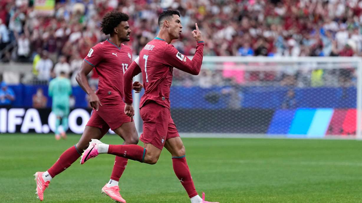 Portugal's Cristiano Ronaldo, right, celebrates after scoring the opening goal during the World Cup Group K soccer match between Portugal and Uzbekistan in Houston, Tuesday, June 23, 2026.