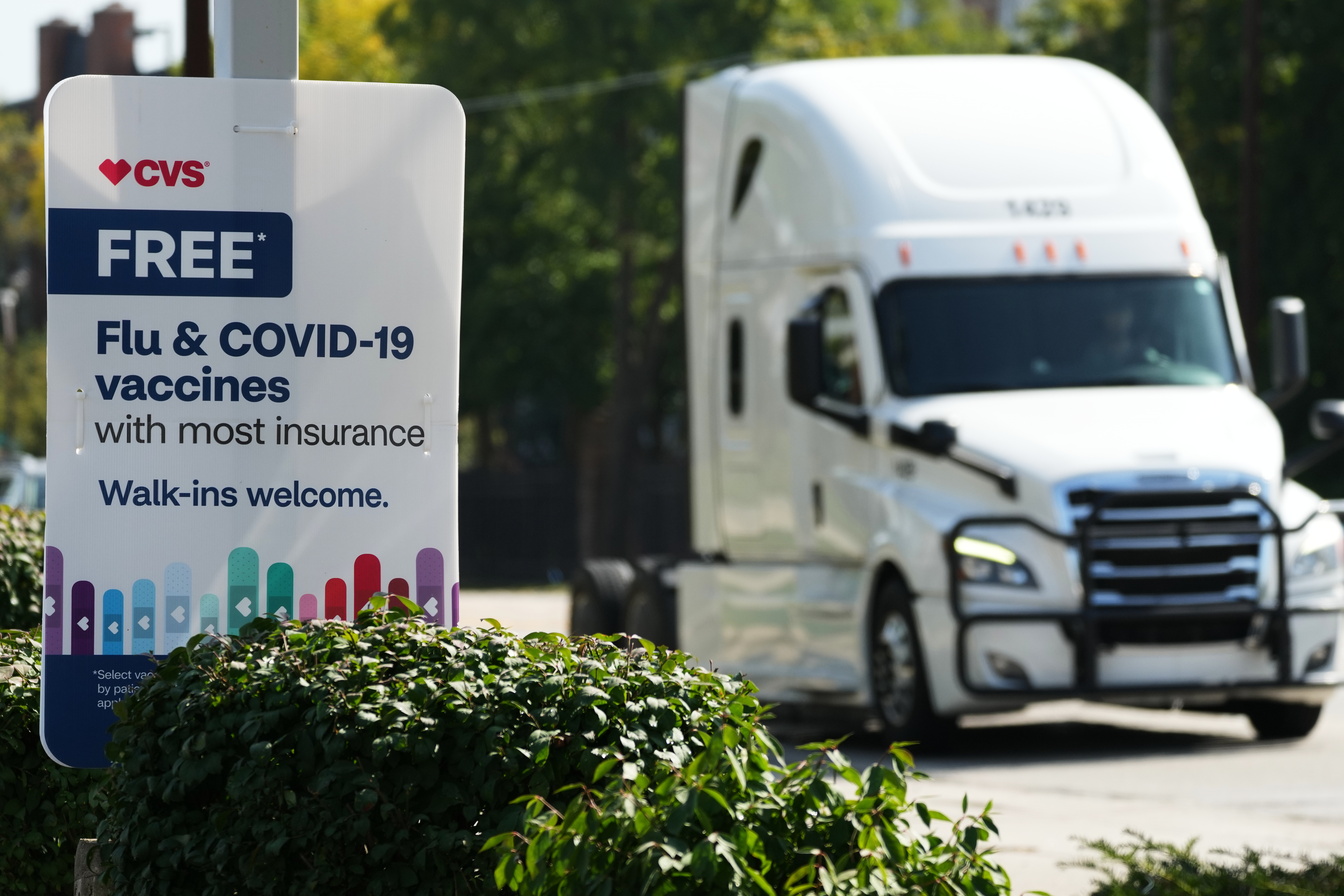 A sign for flu & COVID-19 vaccines is displayed outside a CVS store in Buffalo Grove, Ill., Sept. 23, 2025. There are many pharmacies that offer both shots, experts say.