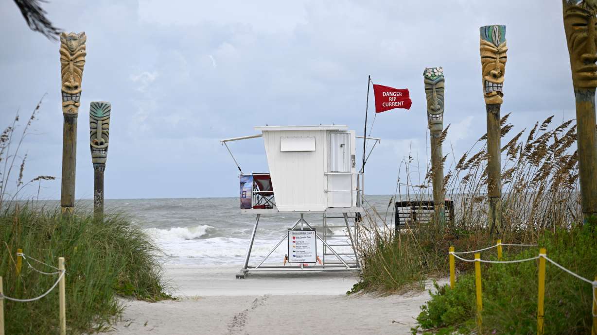 A "Danger Rip Current" flag flies as Tropical Storm Imelda passes offshore Sept. 29, in Cocoa Beach, Fla. Lifeguards say to not only not panic when caught in a rip current, but to flip over and float out of the danger.
