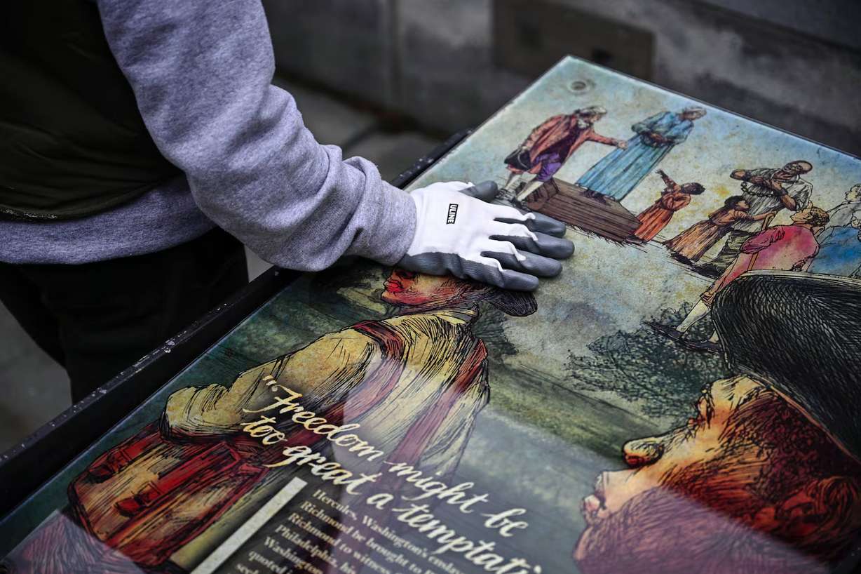 A National Parks Service worker puts his hand on a panel that was part of an exhibit on slavery at the President's House Site in Philadelphia to be put back, Feb. 19. Opposition is growing to President Donald Trump's directive to remove "disparaging" information from national parks.