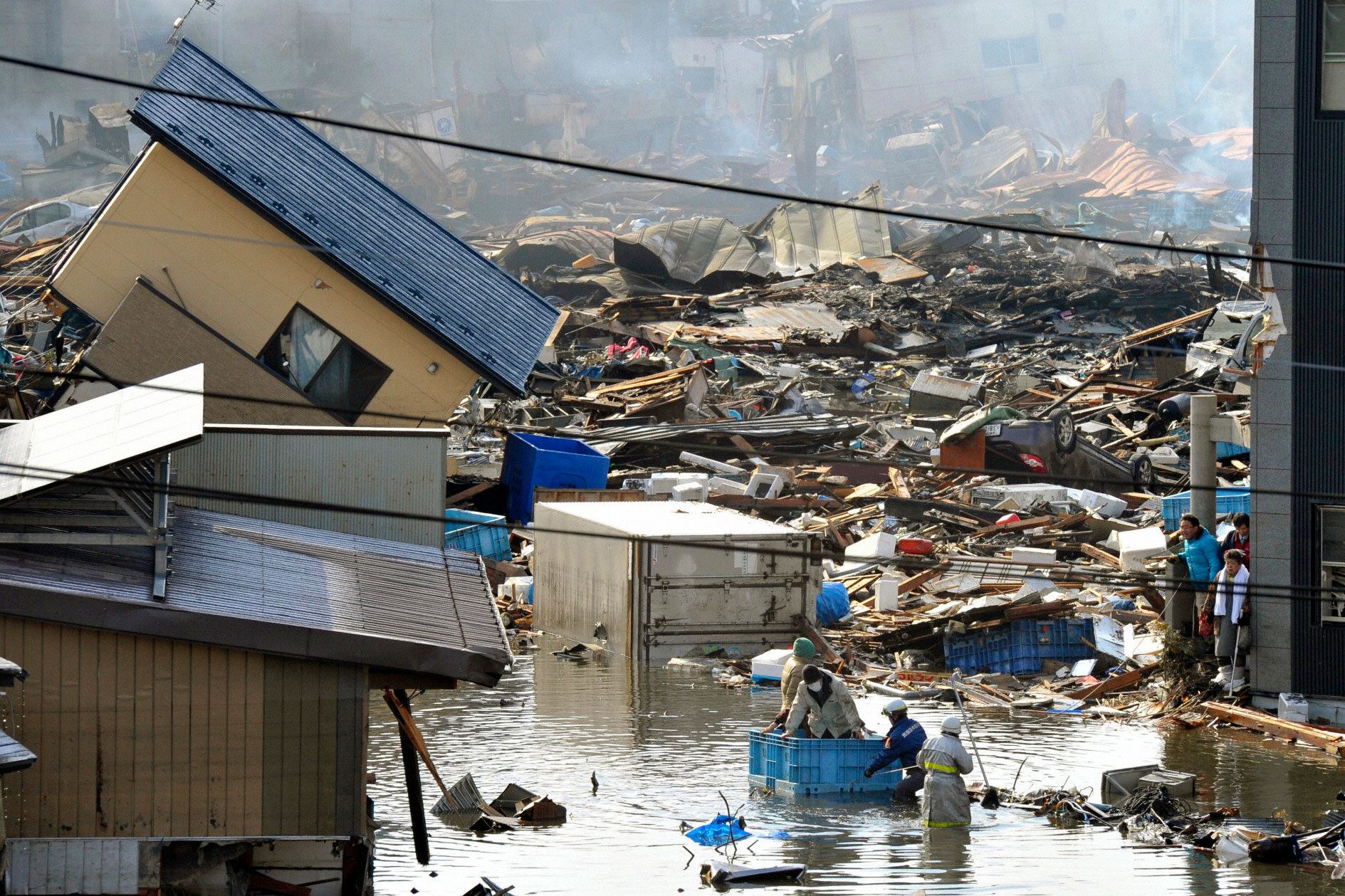People in a floating container are rescued from a building following the earthquake and tsunami in Miyagi Prefecture, northeastern Japan, March 11, 2011. A new study said that the quake caused a shift of the county by almost 6 millimeters, and was felt to the Earth's core.