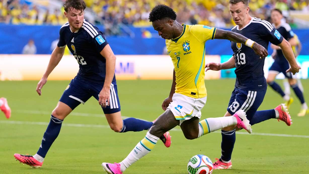Brazil's Vinicius Junior (7) battles for the ball with with Scotland's Nathan Patterson (22) and Lewis Ferguson (19) during the World Cup Group C soccer match between Scotland and Brazil in Miami Gardens, Fla., Wednesday, June 24, 2026.
