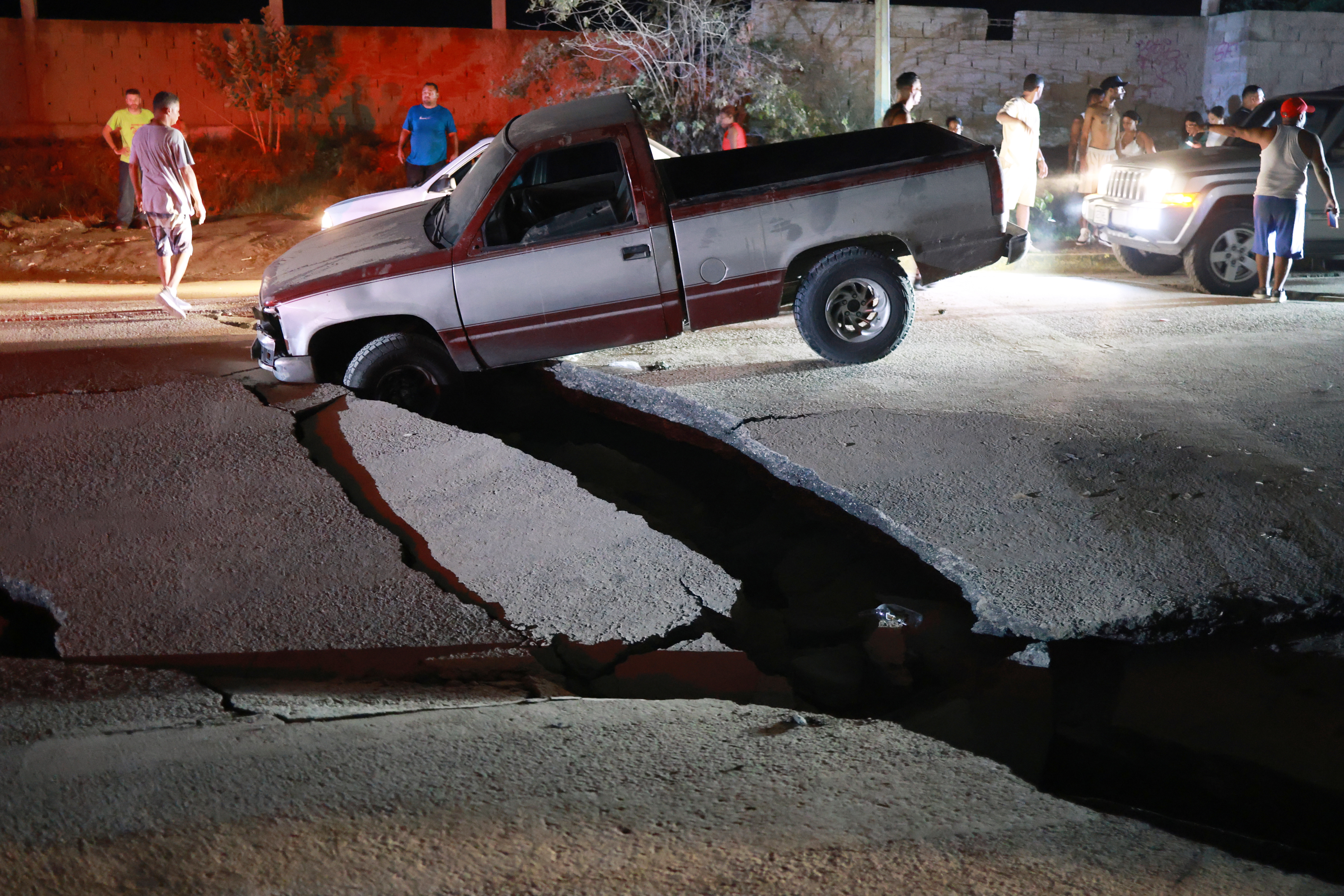 A vehicle is trapped in a fissure caused by an earthquake in La Guaira, Venezuela, Thursday. La Guaira was the hardest hit area by two powerful earthquakes on Wednesday.