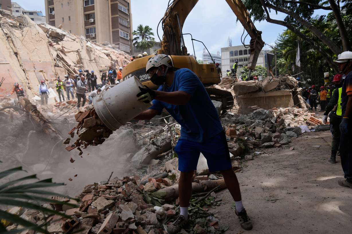 Residents help to remove rubble from a collapsed building in Caracas, Venezuela, Thursday, a day after successive powerful earthquakes struck the country. The death toll from the earthquake reached 589, acting President Delcy Rodriguez said early Friday.