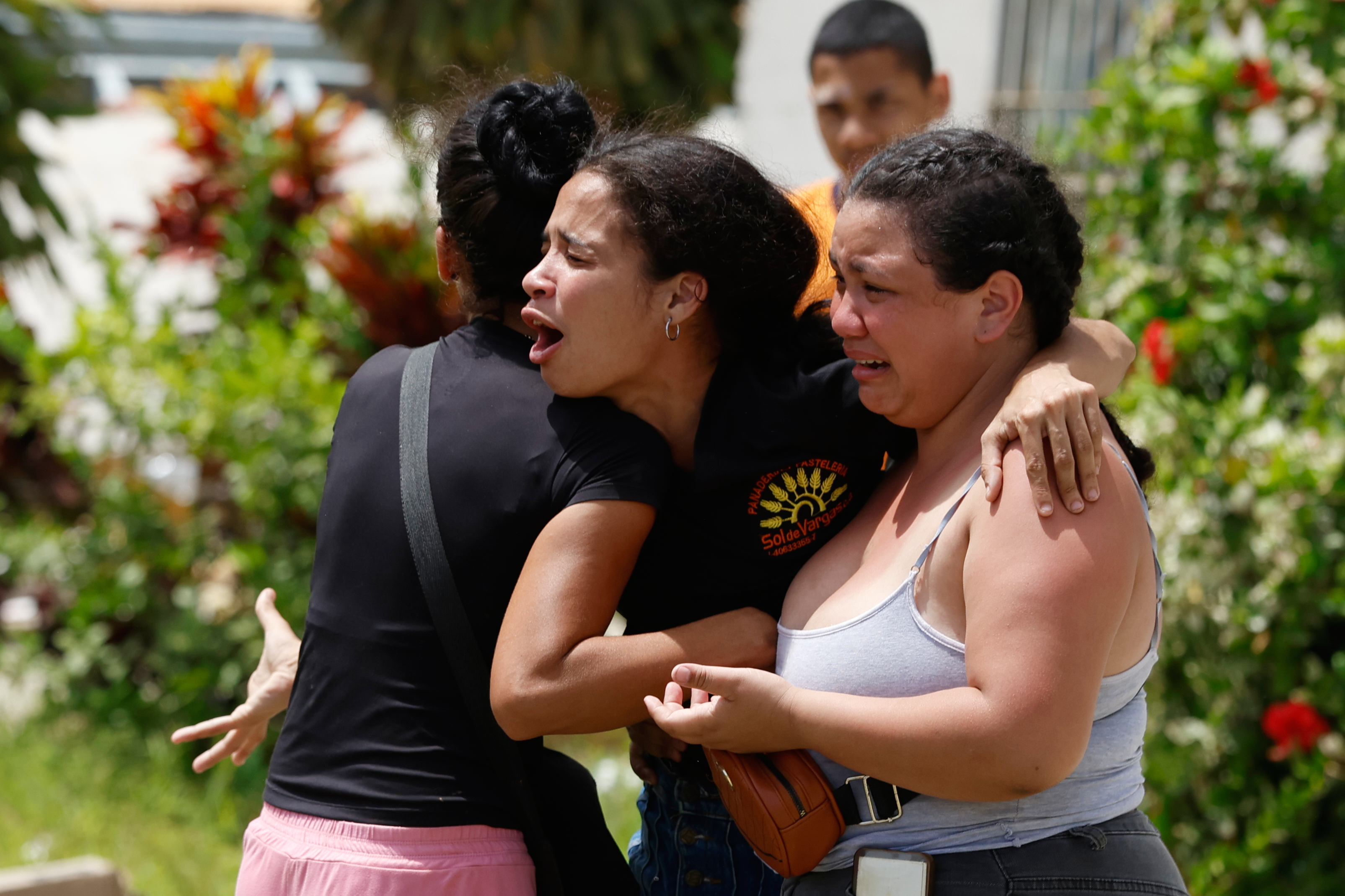 Neighbors comfort Gabriela Rojas, center, as she mourns in front of her damaged home, where two of her children died during earthquakes that struck La Guaira, Venezuela, Thursday. Officials say over 4,300 people are still missing.