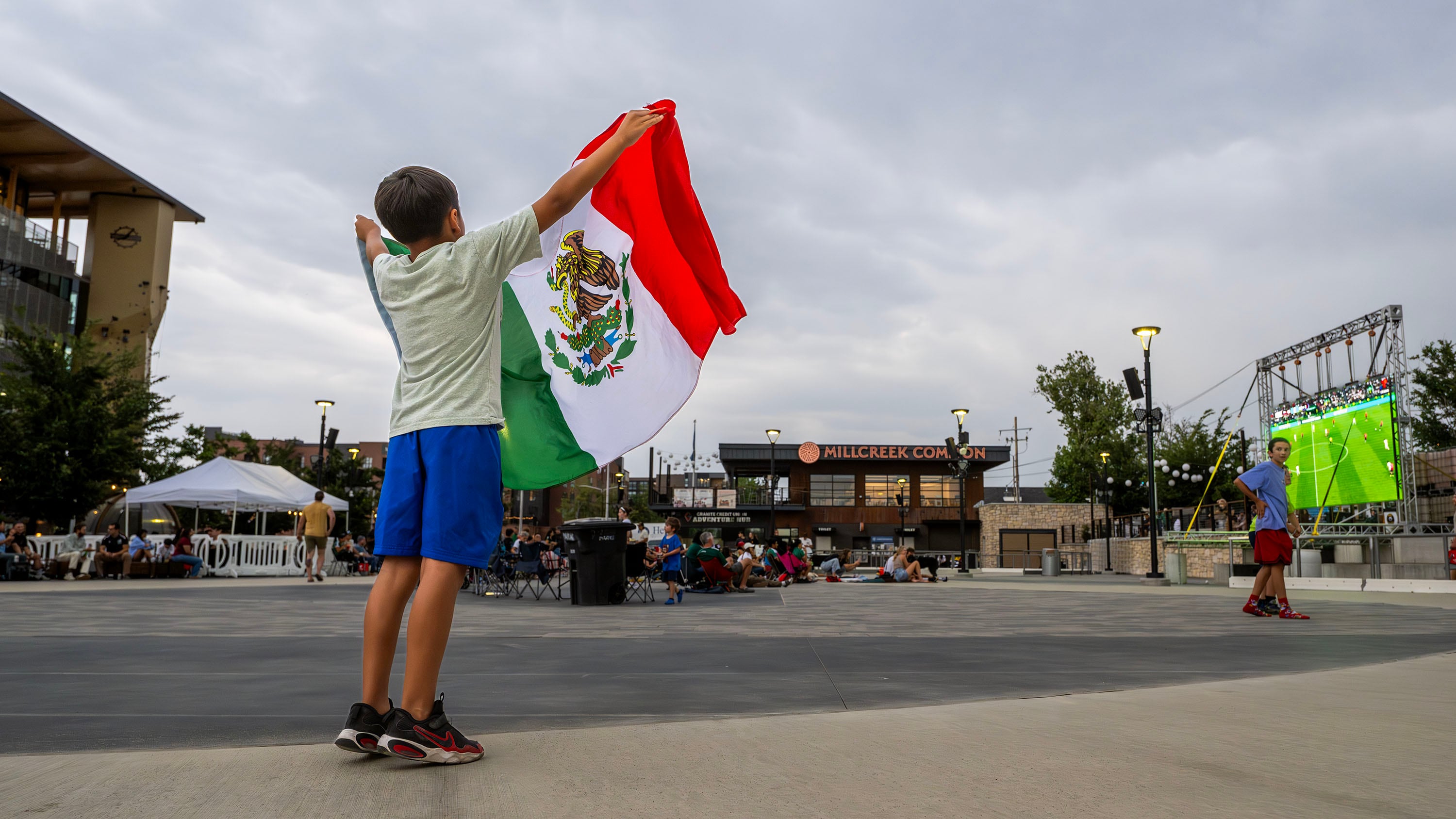 Julian Soto holds up a Mexico flag as he and other soccer fans gather at the Millcreek Common to watch Mexico and the Czech Republic play in the World Cup on Wednesday. A new Deseret News poll found that over half of Utahns plan to watch at least one World Cup match.