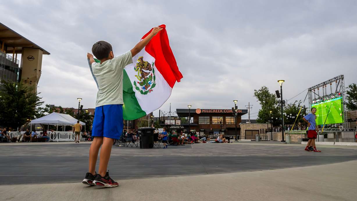Julian Soto holds up a Mexico flag as he and other soccer fans gather at the Millcreek Common to watch Mexico and the Czech Republic play in the World Cup on Wednesday. A new Deseret News poll found that over half of Utahns plan to watch at least one World Cup match.
