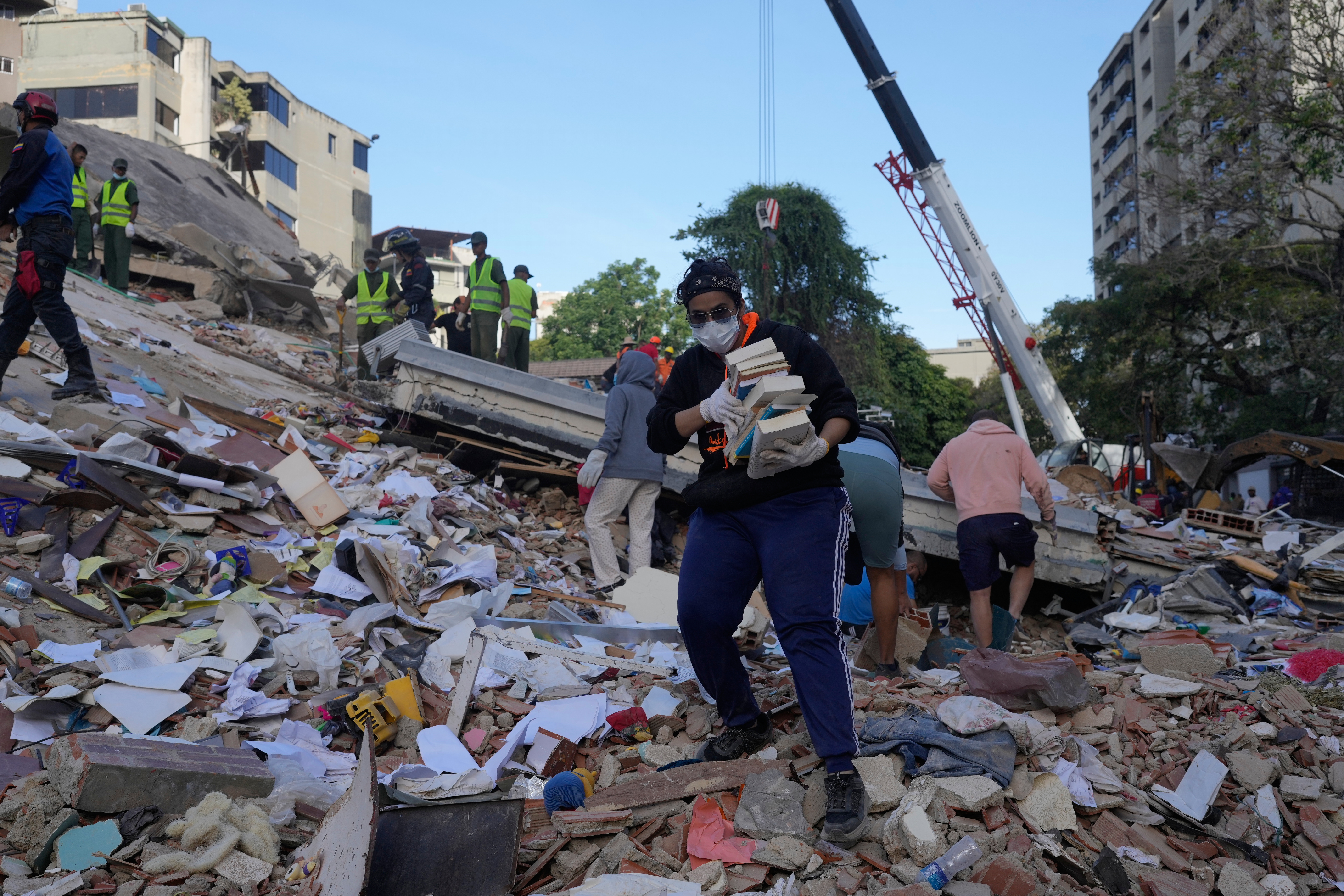 Residents search through the rubble of a building that collapsed in an earthquake in Caracas, Venezuela, Thursday. Acting President Delcy Rodriguez appealed to businesses to make heavy equipment available for residents to dig through for loved ones.