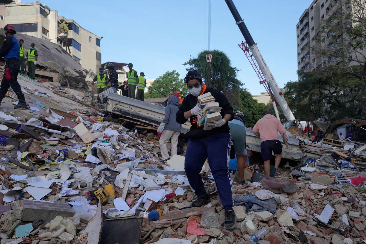 Residents search through the rubble of a building that collapsed in an earthquake in Caracas, Venezuela, Thursday. Acting President Delcy Rodriguez appealed to businesses to make heavy equipment available for residents to dig through for loved ones.