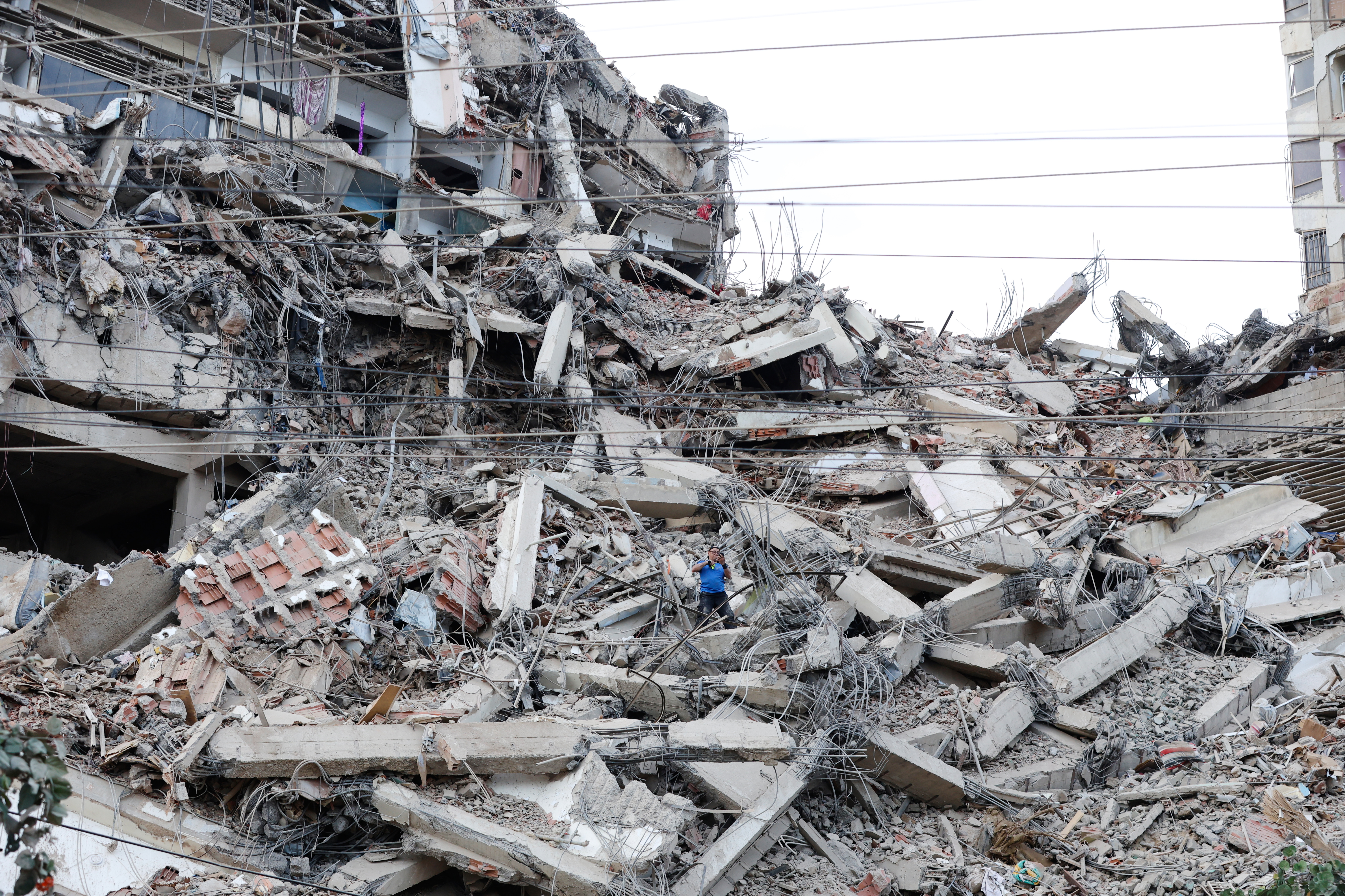 A man walks among the rubble of a building that collapsed in earthquakes the previous day in La Guaira, Venezuela, Thursday. International assistance began arriving on Friday to help in recovery efforts, acting President Delcy Rodriguez said.
