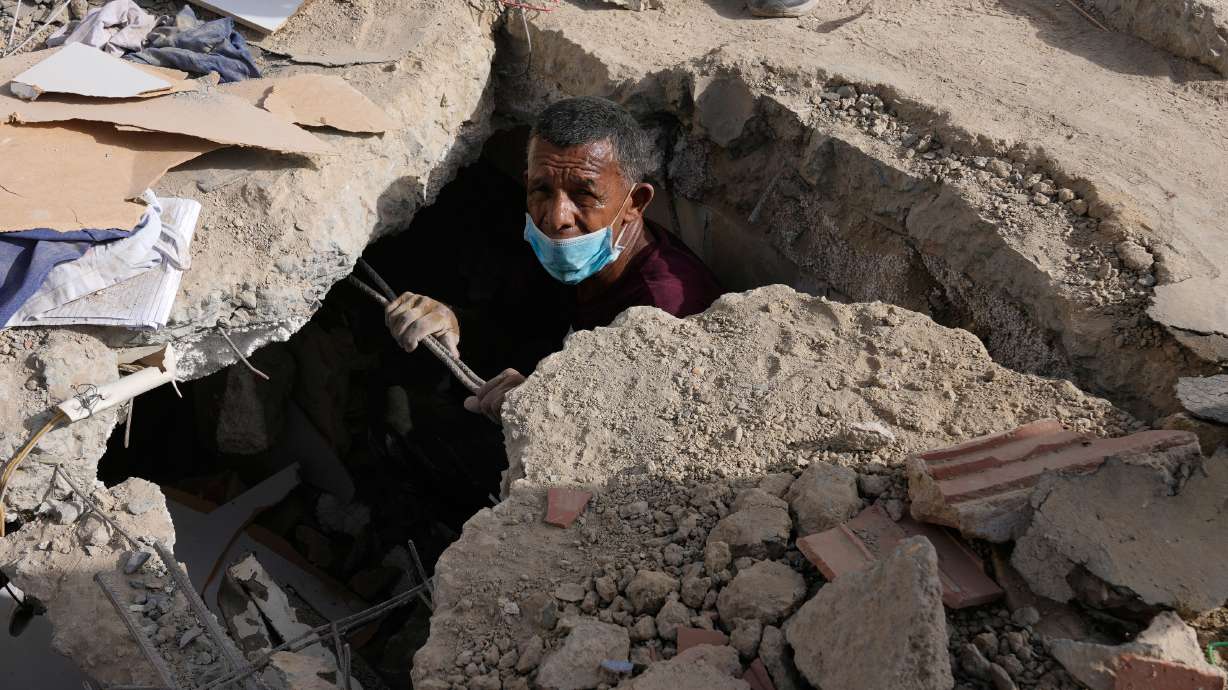 Franklin Fuentes searches for missing relatives in the collapsed building where they lived two days after earthquakes struck La Guaira, Venezuela, Friday. Fuentes is one of many doing the same as the death toll from the quakes rose to 920.