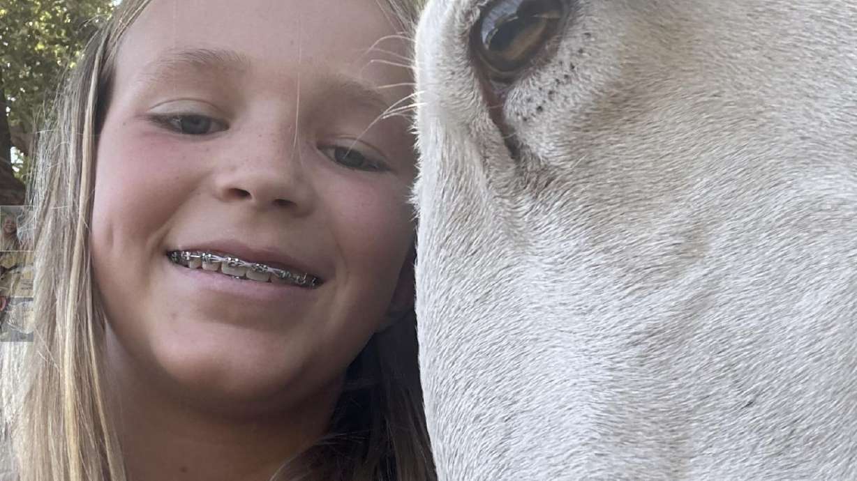 Halle Wiley, 11, poses with her lamb, River, which was found roaming a golf course in southern Utah and, after no one claimed it, was adopted by the family.