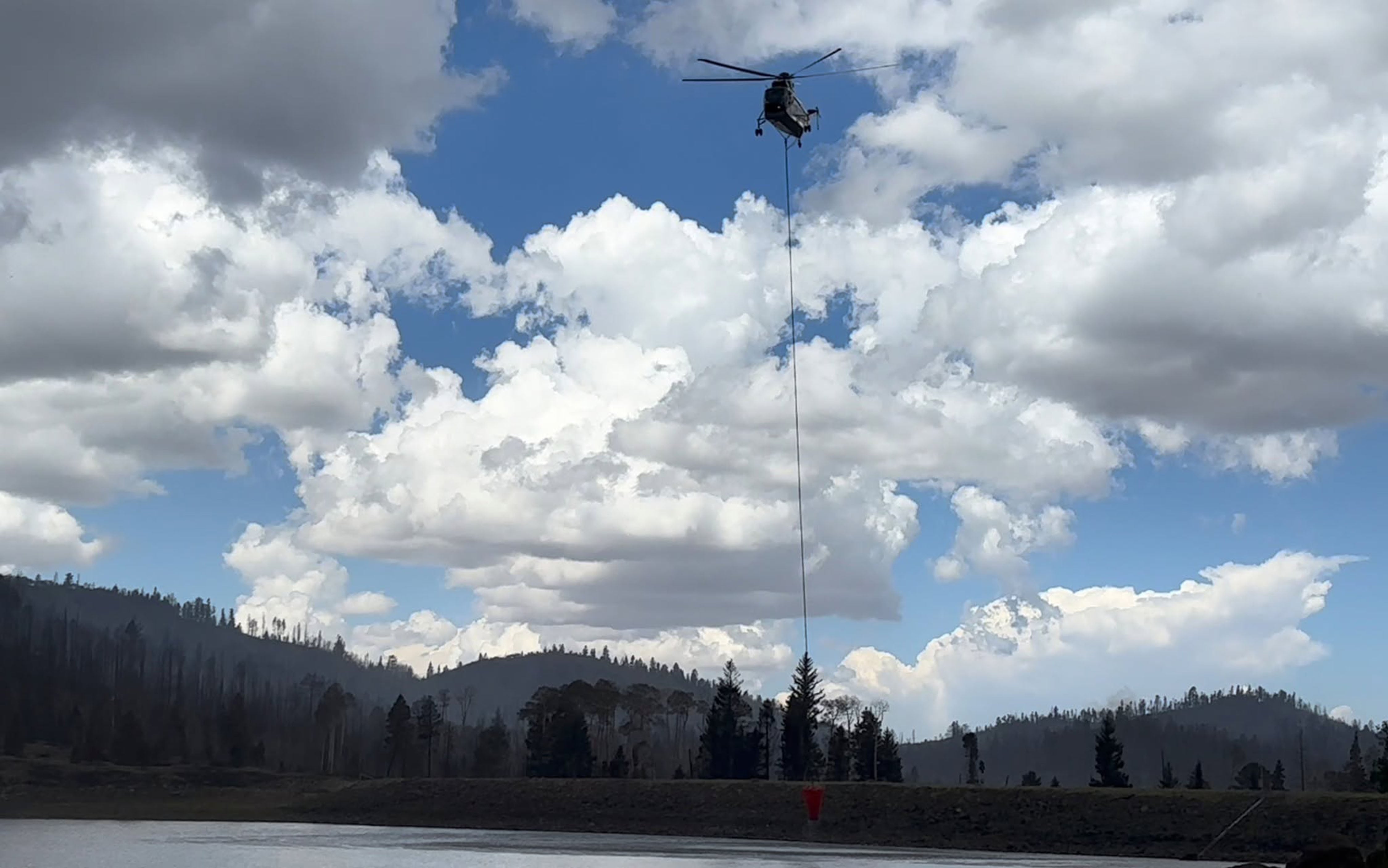 A helicopter dipping out of Kents Lake on Thursday, June 25, 2026, while fighting the Cottonwood Fire.