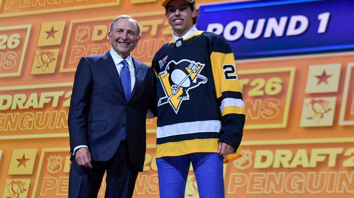 Liam Ruck, right, stands with NHL Commissioner Gary Bettman after being drafted by the Pittsburgh Penguins during the NHL hockey draft Friday, June 26, 2026, in Buffalo, N.Y.