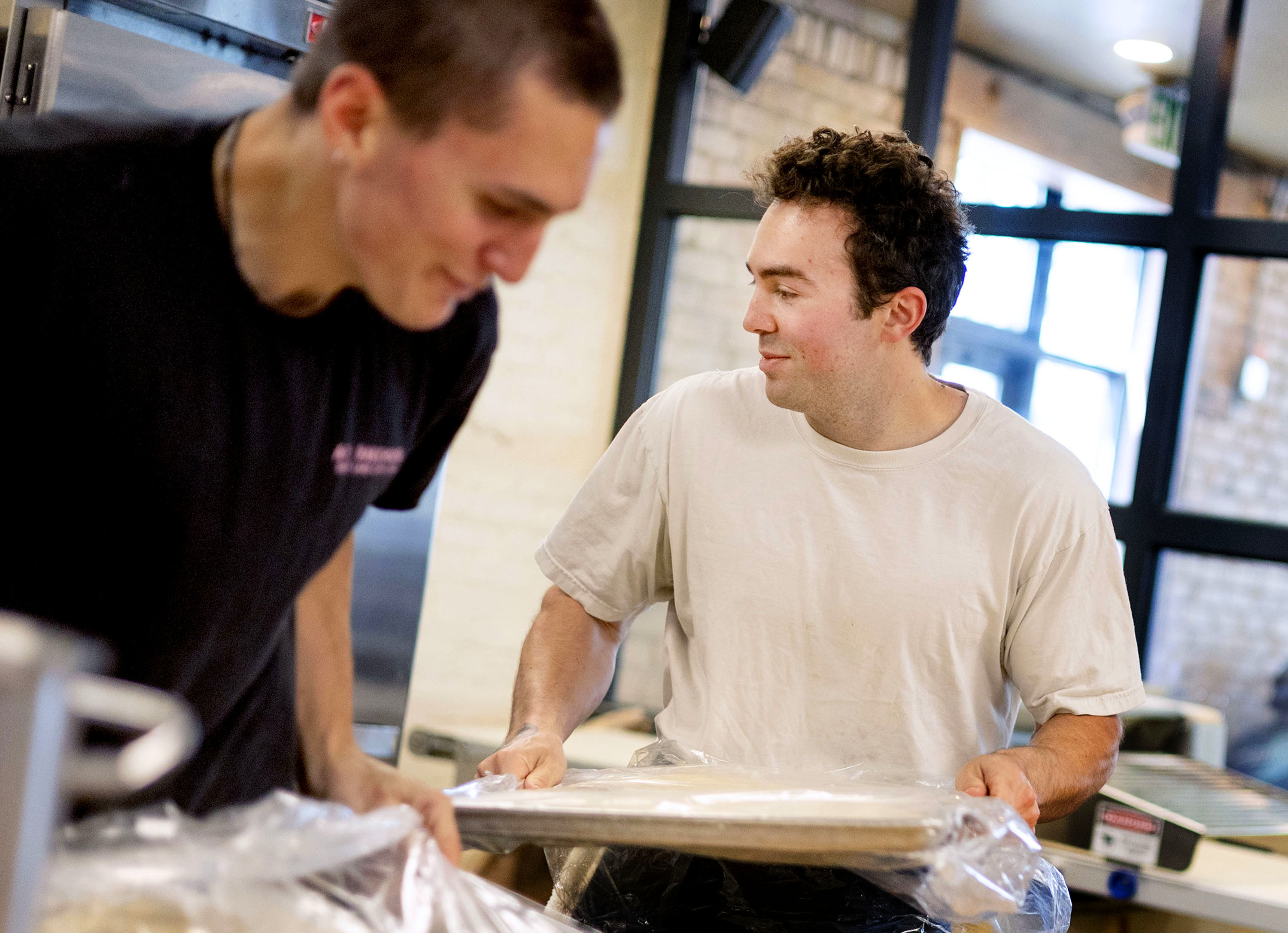 Eli Fuhrman, owner of All Purpose Bakehouse, races for fun to get dough degassed with Theo Zimmer, at All Purpose Bakehouse in Salt Lake City on Wednesday. Fuhrman opened the bakery in February.