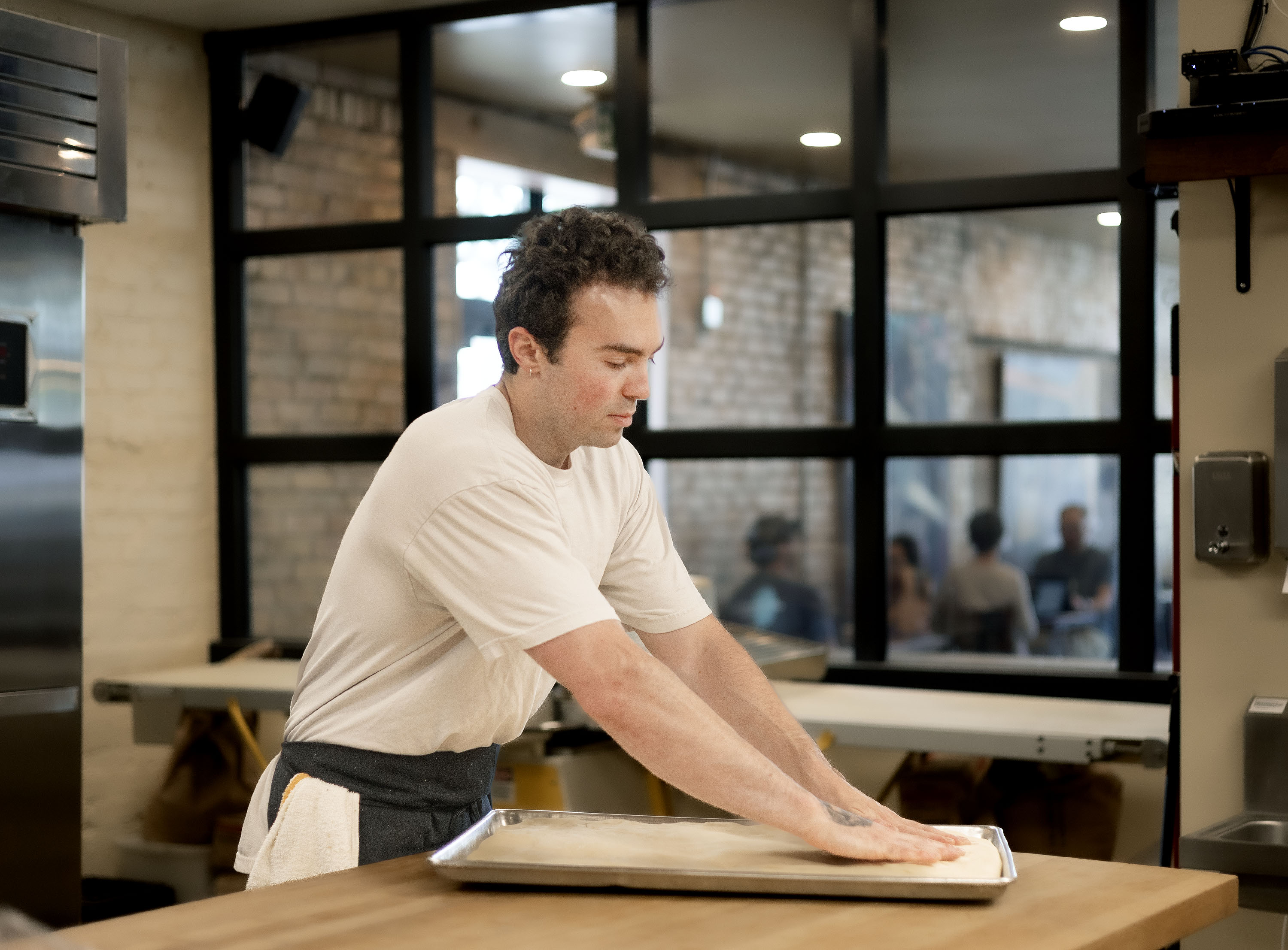 Eli Fuhrman, owner of All Purpose Bakehouse, degasses dough at All Purpose Bakehouse in Salt Lake City on Wednesday. Fuhrman was born in Salt Lake City but recently moved back from Boulder, Colorado, to open the bakehouse.