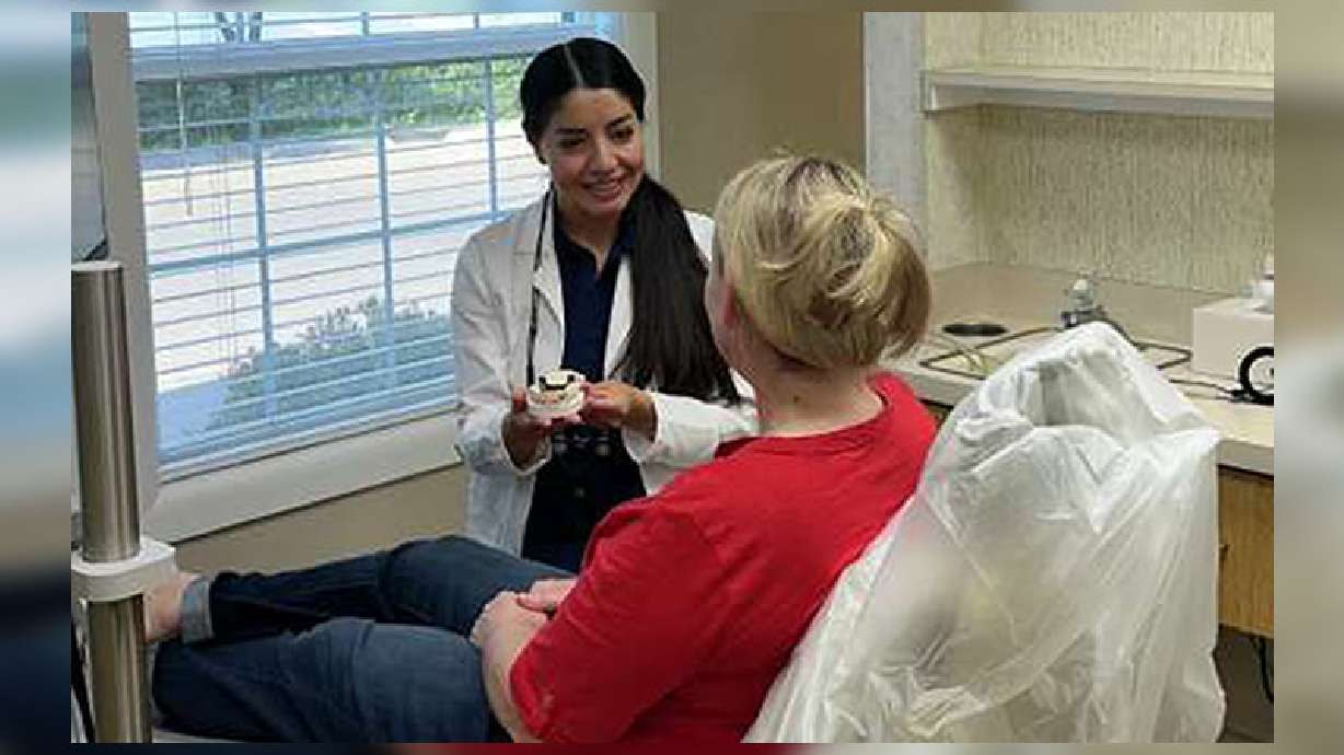 Dr. Cecelia Serrato works with a patient at Creekside Dental. She recently was able to purchase the outfit and continue her business.
