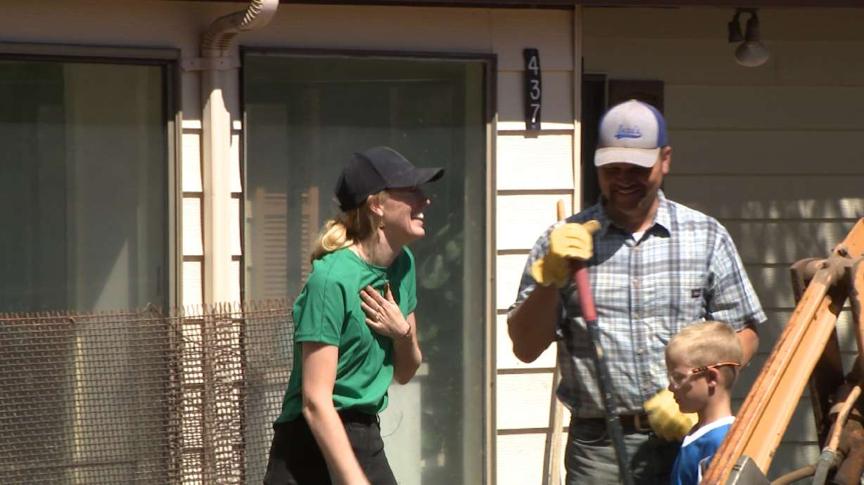 Mo Larsen talks with a volunteer outside her home Saturday.