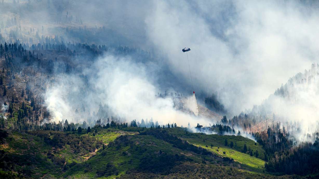 A helicopter drops water on the Cottonwood Fire burning near Beaver, Utah, on Saturday.