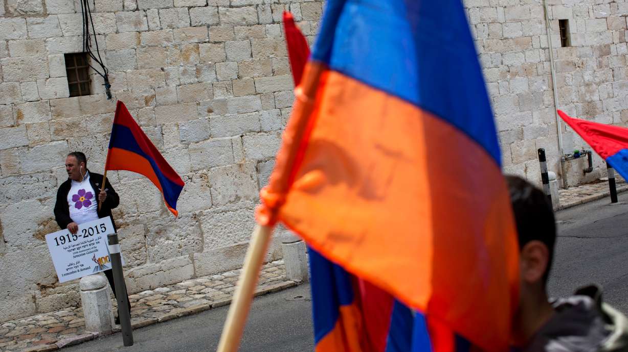 Armenians hold their national flag during a ceremony to commemorate the mass killings of Armenians by the Ottoman Empire, in Jerusalem, Israel, April 24, 2015. Israel's Cabinet unanimously approved a proposal on Sunday to designate violence against Armenians by the Ottoman Empire during World War I as a genocide.