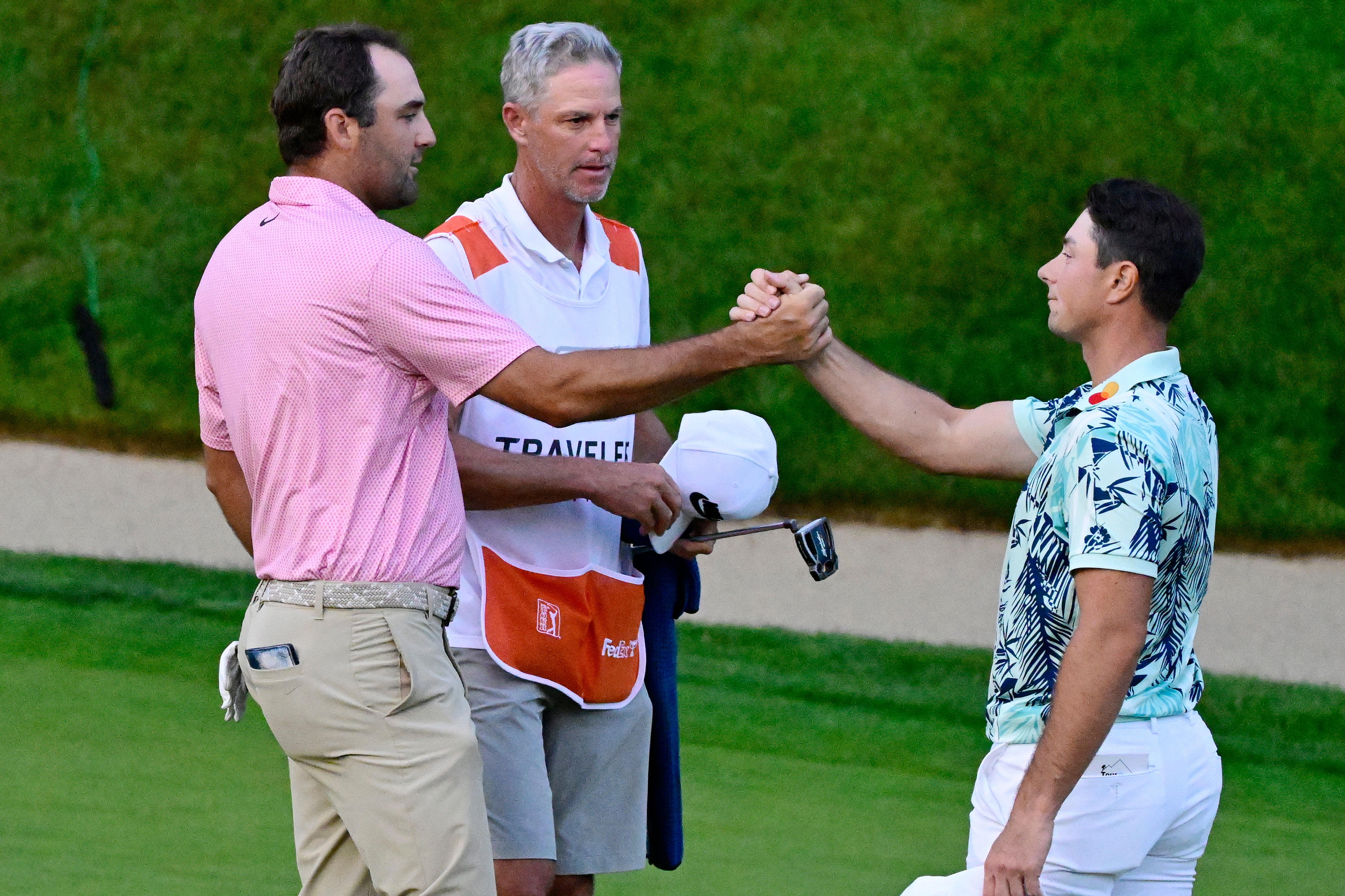 Scottie Scheffler, left, shakes hands with Viktor Hovland, right, of Norway, after finishing tied in the final round of the Travelers Championship golf tournament at TPC River Highlands, Sunday, June 28, 2026, in Cromwell, Conn. 