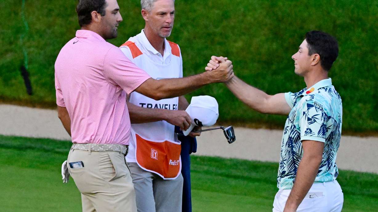 Scottie Scheffler, left, shakes hands with Viktor Hovland, right, of Norway, after finishing tied in the final round of the Travelers Championship golf tournament at TPC River Highlands, Sunday, June 28, 2026, in Cromwell, Conn.