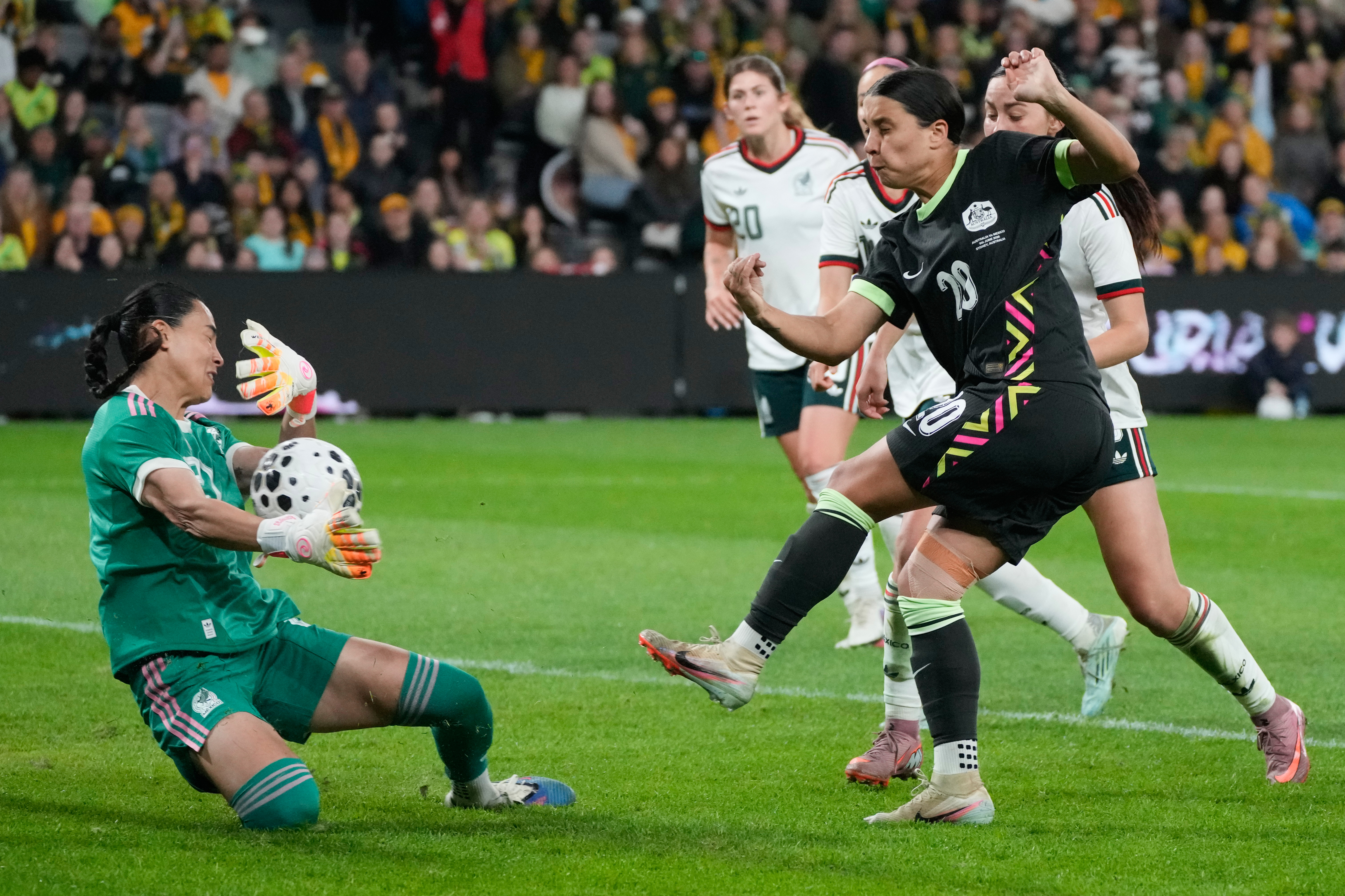 Mexico's goalkeeper Esthefanny Torres, left, blocks a shot from Australia's Sam Kerr during their women's soccer friendly international in Sydney, Tuesday, June 9, 2026. 