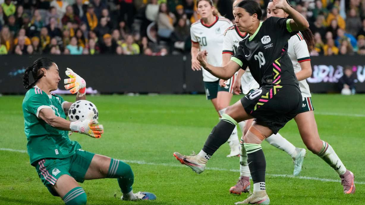Mexico's goalkeeper Esthefanny Torres, left, blocks a shot from Australia's Sam Kerr during their women's soccer friendly international in Sydney, Tuesday, June 9, 2026.