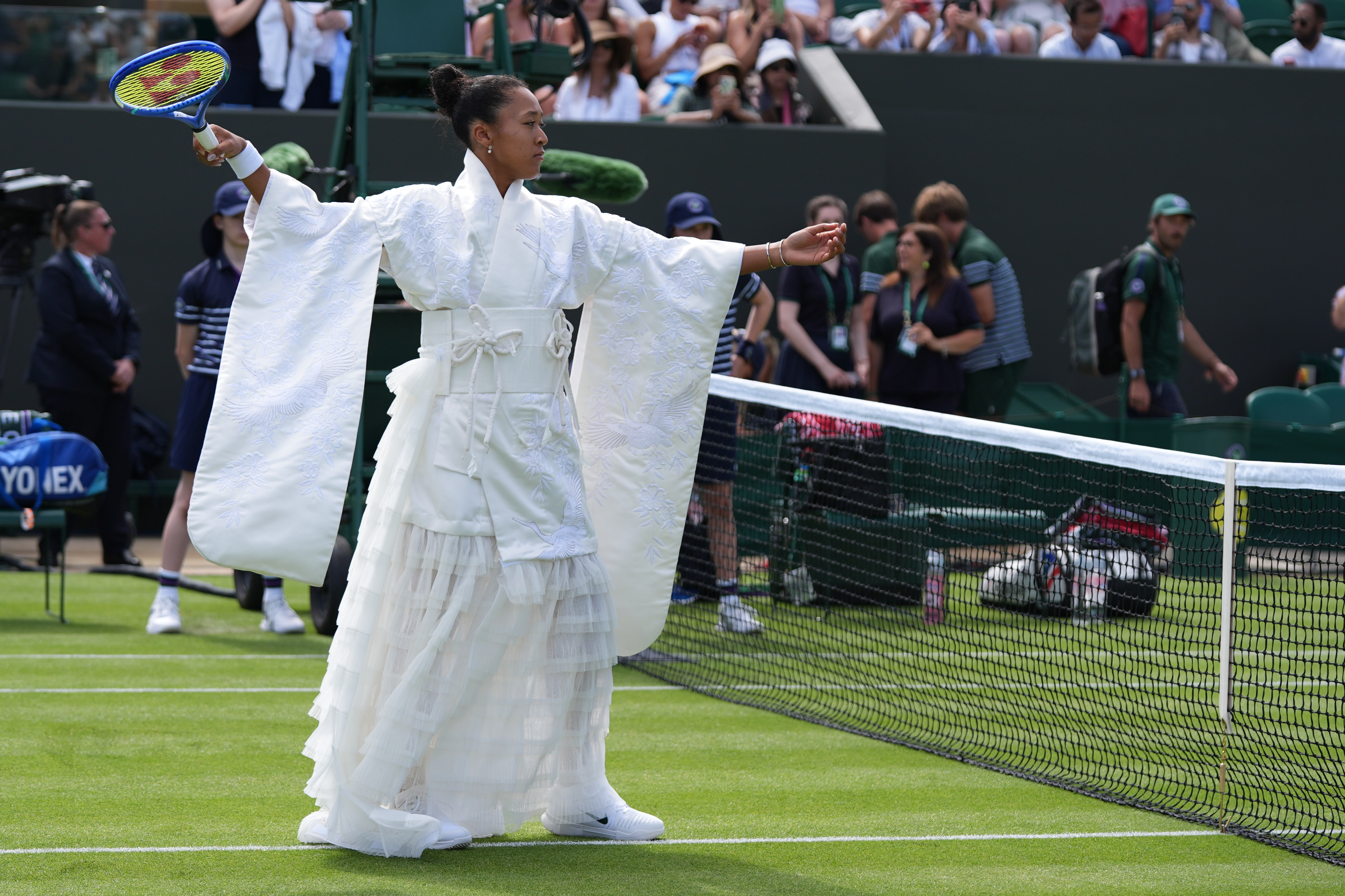 Naomi Osaka of Japan walks into the court to play against Elsa Jacquemot of France in their first round women's singles match at the Wimbledon Tennis Championships in London, Monday, June 29, 2026. 