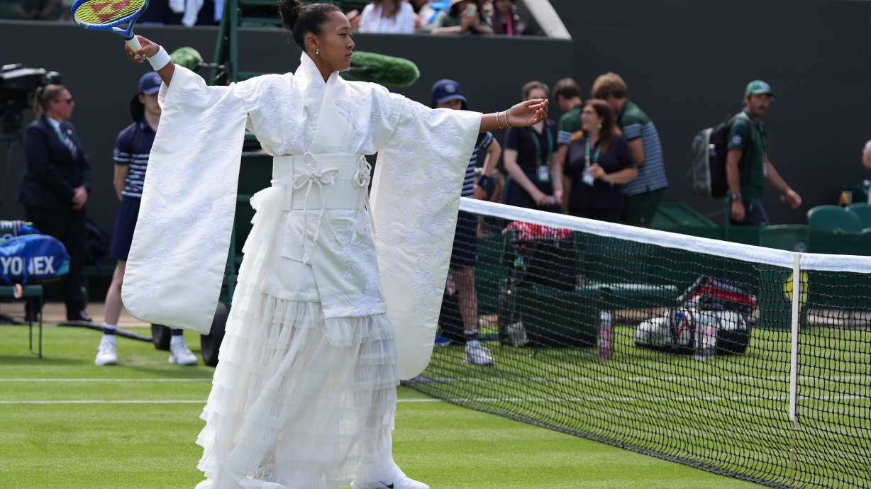 Naomi Osaka of Japan walks into the court to play against Elsa Jacquemot of France in their first round women's singles match at the Wimbledon Tennis Championships in London, Monday, June 29, 2026.
