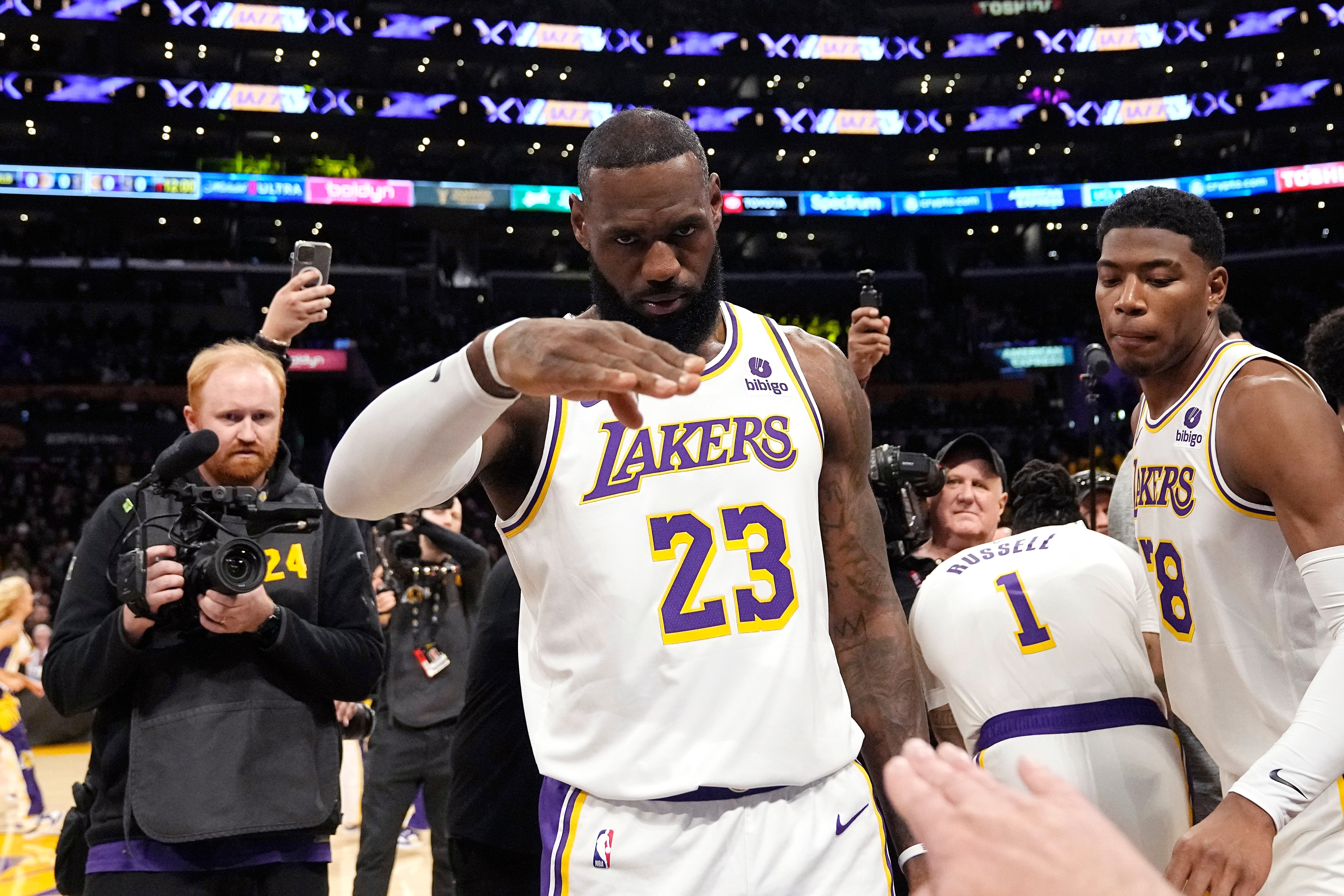 FILE - Los Angeles Lakers forward LeBron James salutes public address announcer Lawrence Tanter prior to an NBA basketball game against the Denver Nuggets Saturday, March 2, 2024, in Los Angeles. 