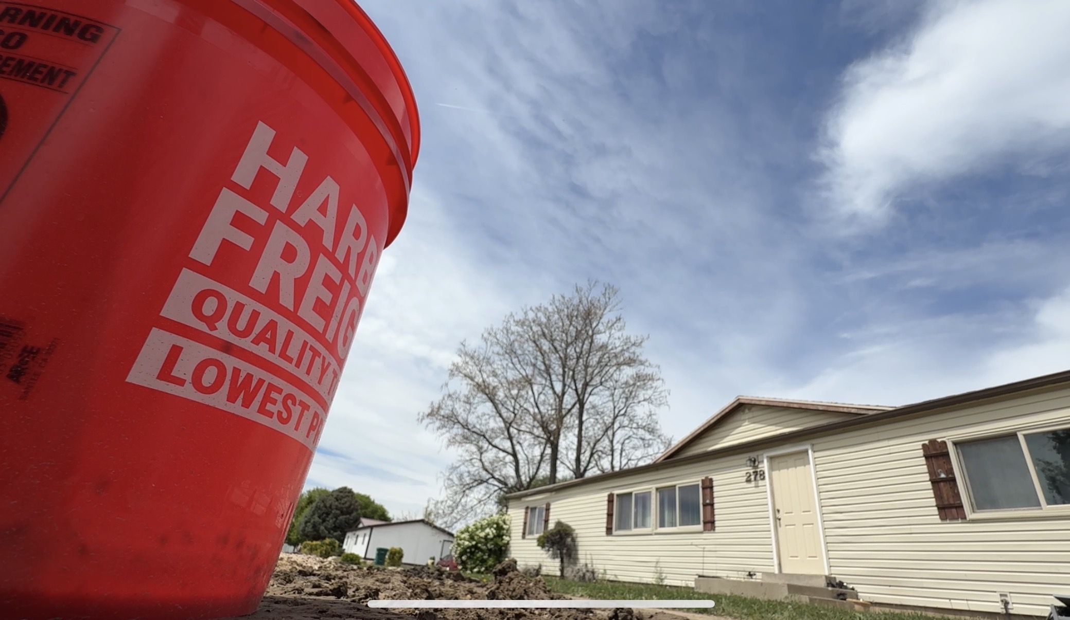 A hardware store bucket sits near an Ogden home after residents say they had to help arrange repairs to a private water line tied to a defunct HOA.