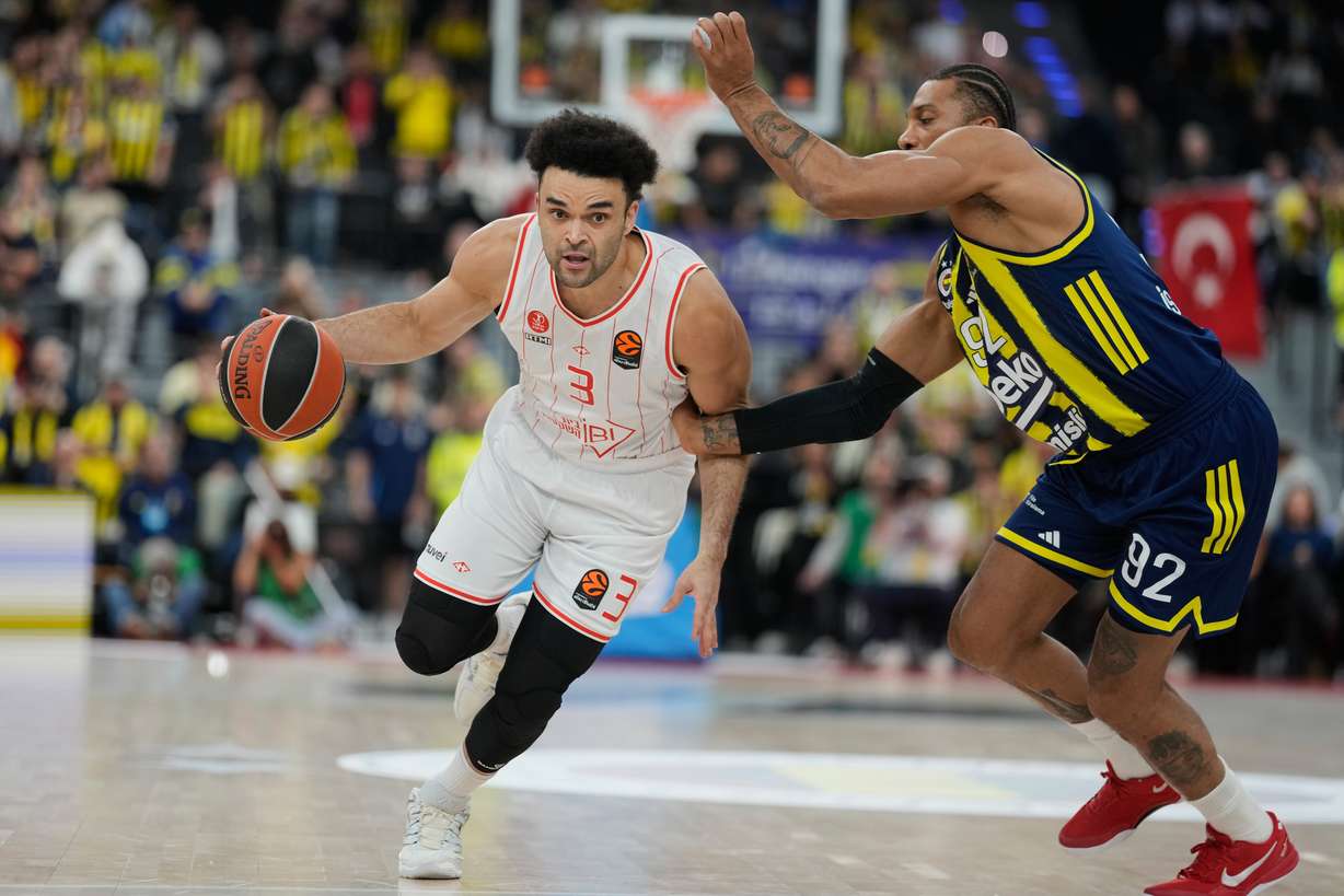 Hapoel's Elijah Bryant, left, and Fenerbahce's Khem Birch challenge for the ball during the Euroleague basketball game between Fenerbahce and Hapoel Tel Aviv in Munich, Thursday, Nov. 13, 2025.
