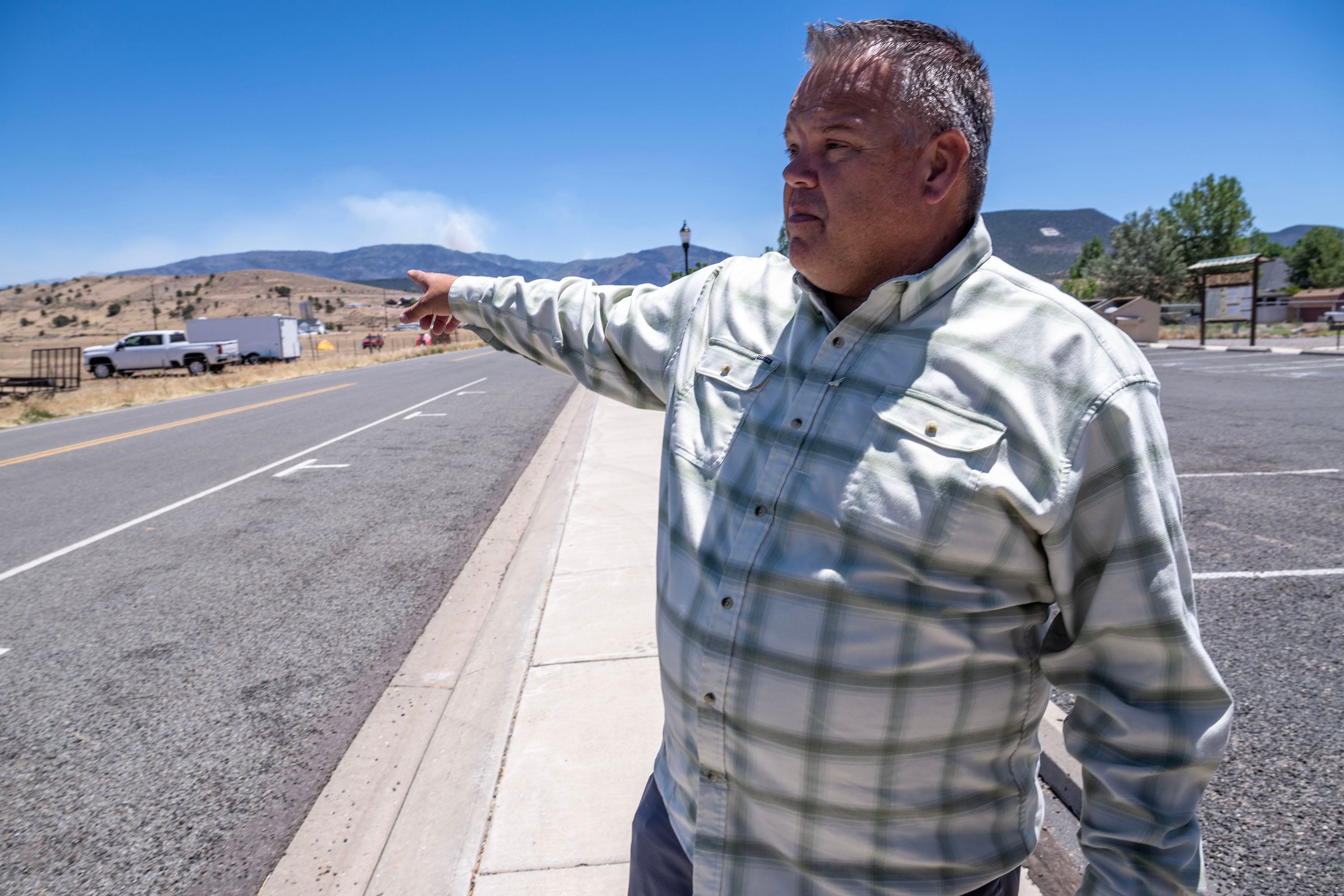 Beaver Mayor Matt Robinson points toward the fire as he describes the events so far as the Cottonwood Fire, burning on the mountains of Beaver, continues on Monday. The mayor called the fire "difficult."
