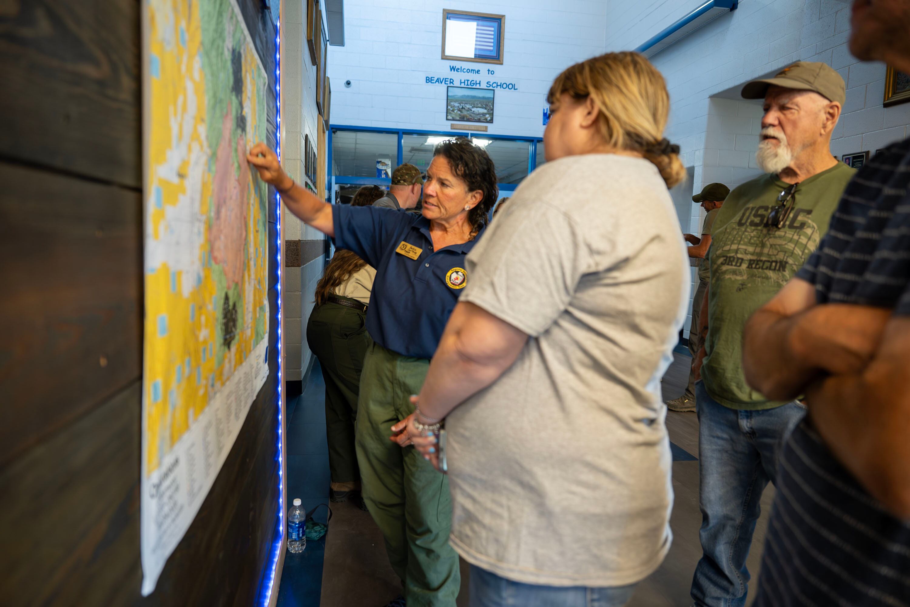 Public information officer Pattie Courtney talks with residents prior to a community meeting at Beaver High School about the Cottonwood Fire burning on the mountains east of Beaver on Monday. About one-third of the town's residents were at the meeting.