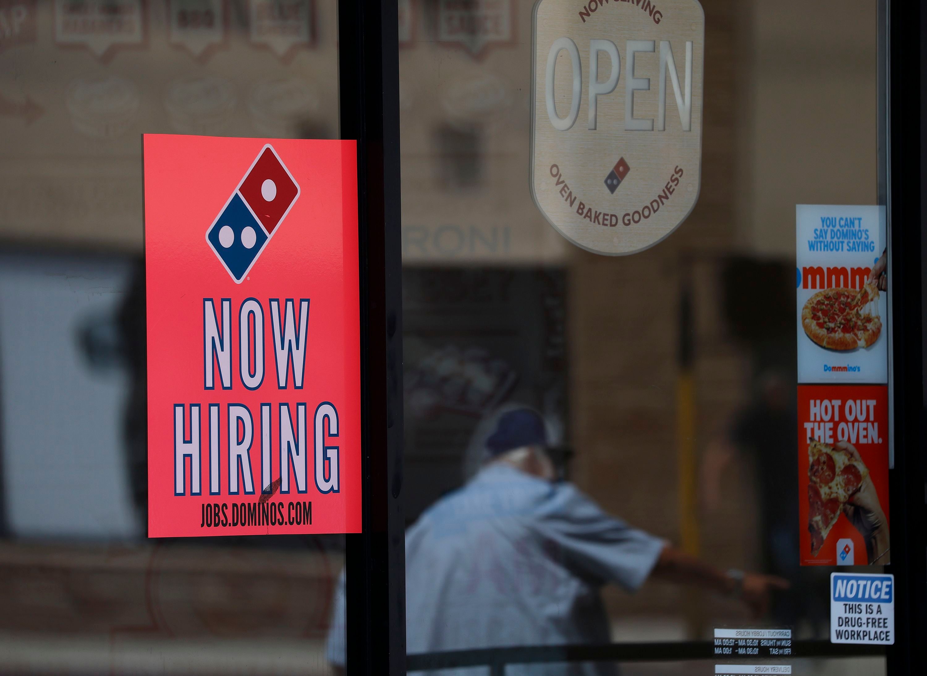 A now hiring sign in the window of a Domino's Pizza restaurant on June 5 in Los Angeles. Americans are navigating a job market that has opportunities for some, but not all, including teenagers.