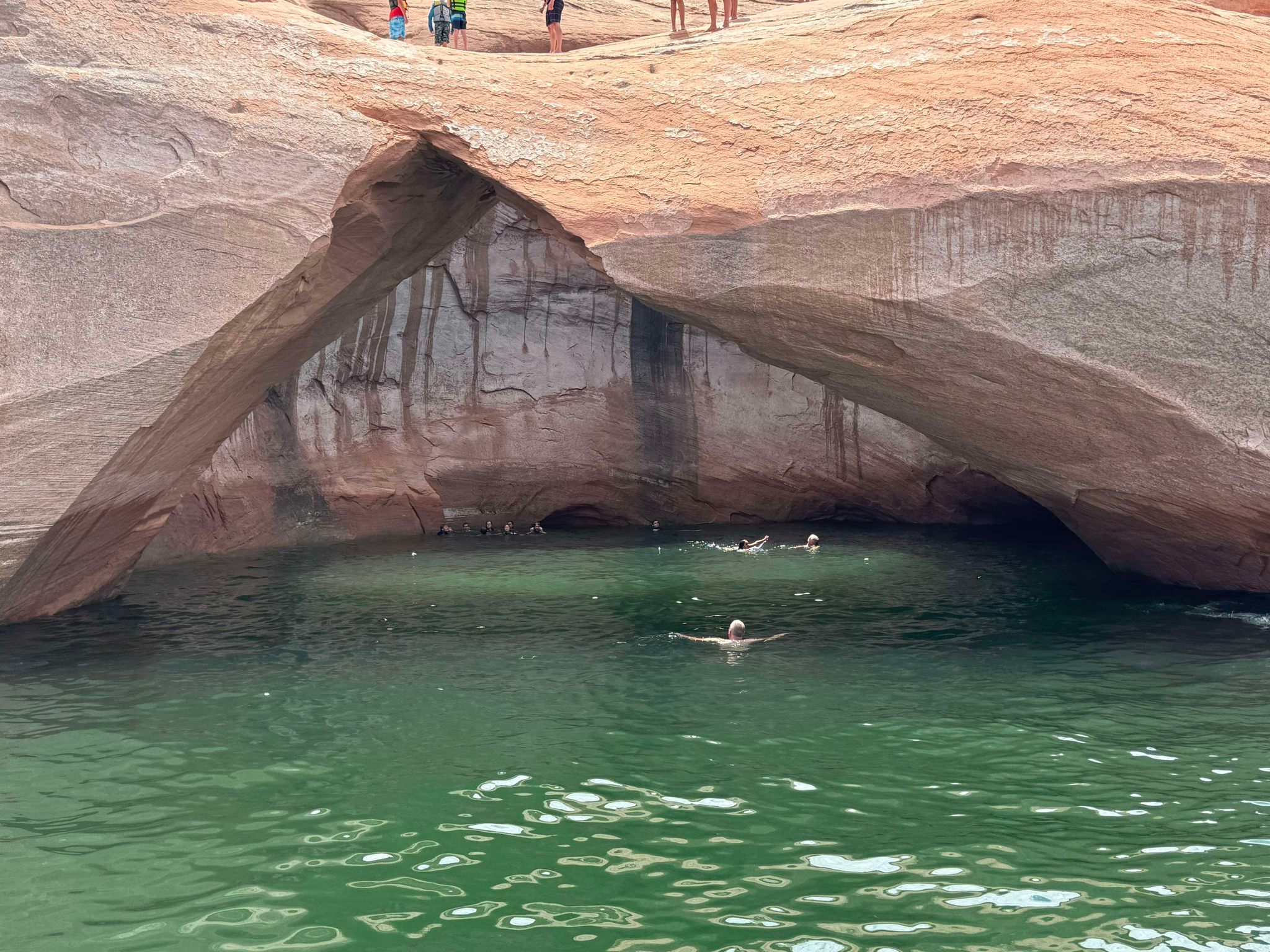 Swimmers explore the cove behind Toilet Bowl arch on Lake Powell. (Greg Sanders)