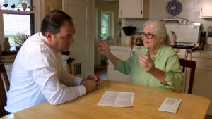 Homeowner Carol Edison shows KSL’s Matt Gephardt the policy for the service plan she bought for her sewer line. (Stuart Johnson, KSL TV)