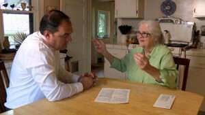 Homeowner Carol Edison shows KSL’s Matt Gephardt the policy for the service plan she bought for her sewer line. (Stuart Johnson, KSL TV)